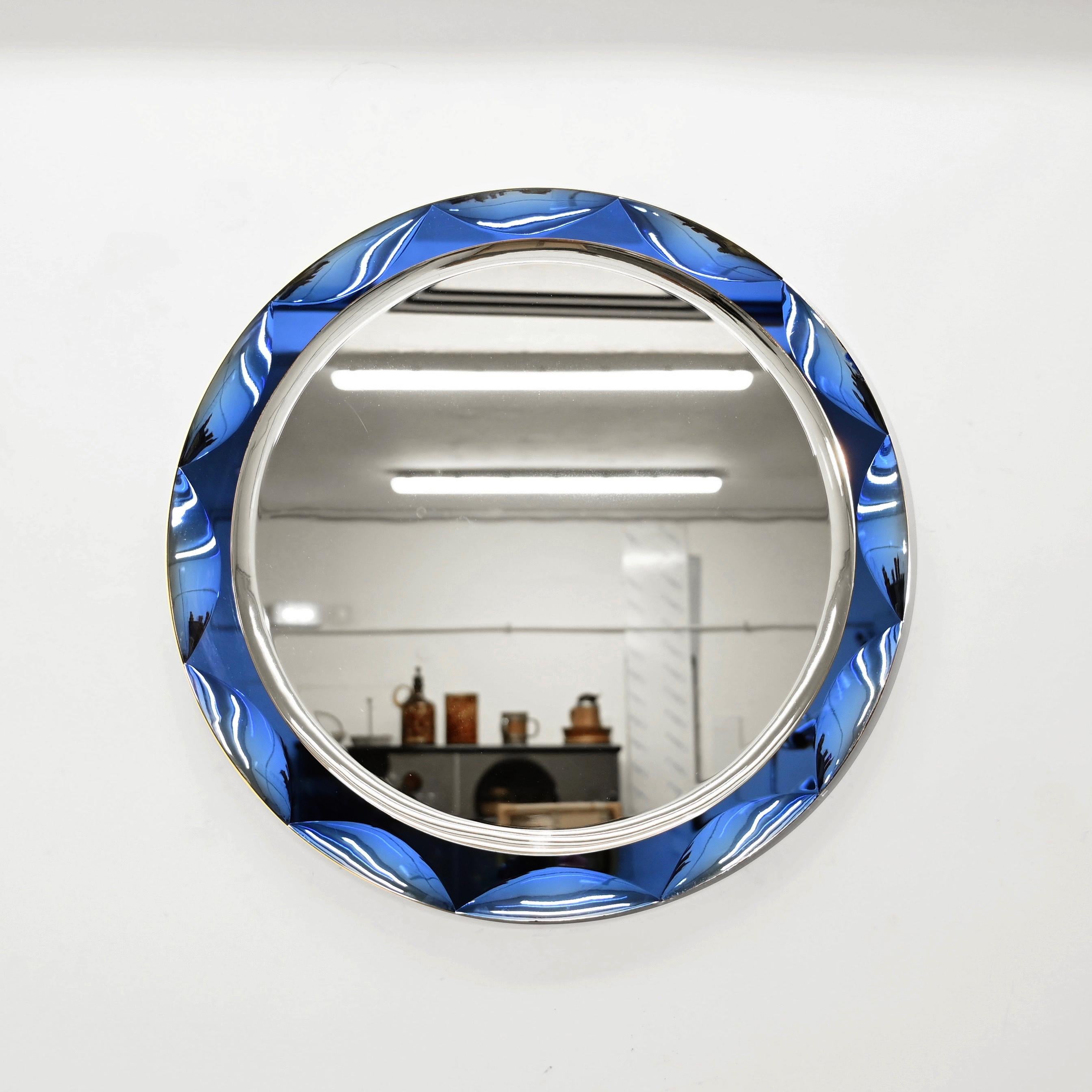 Magnificent round double beveled mirror with a vibrant blue artglass mirror frame. This mind-blowing mirror was made by Galvorame in Italy during the 1970s and is signed on the back.

The mirror features a mind-blowing 