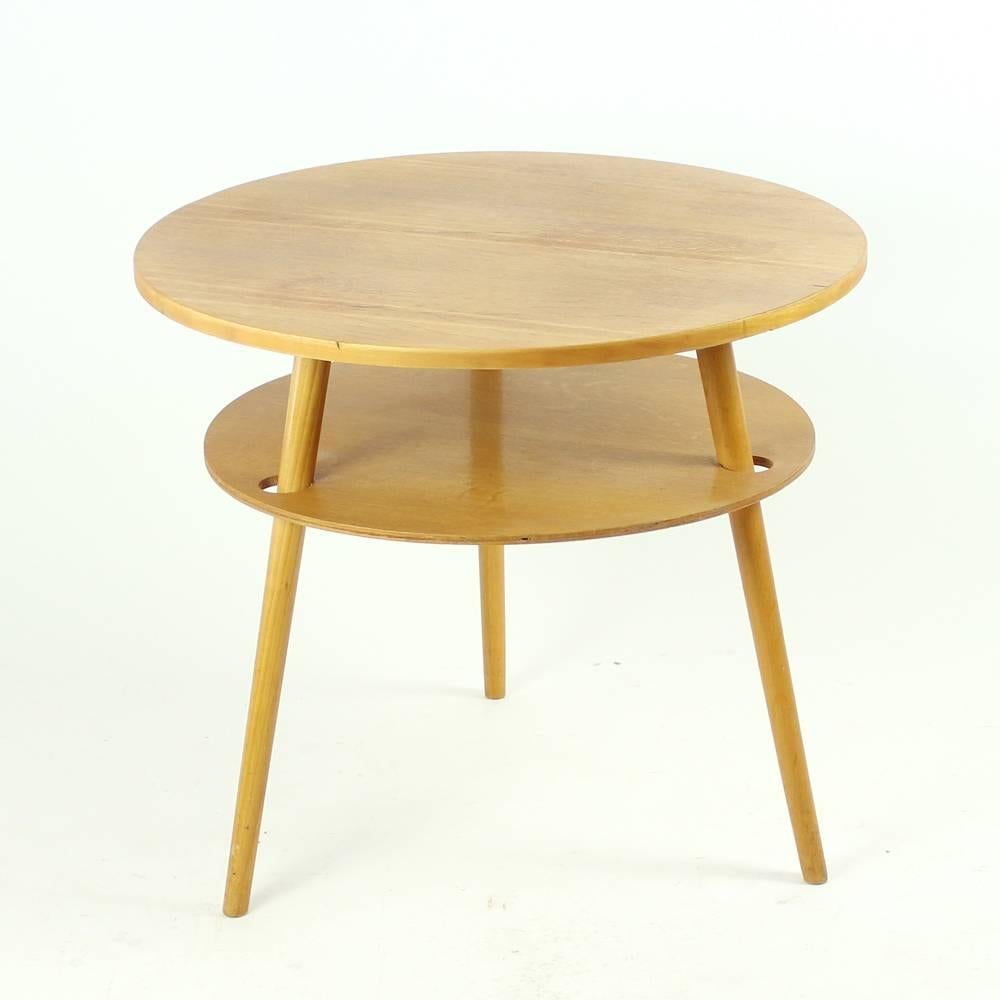 Simple, yet elegant round wooden coffee table sanding on three legs. Completely restored and finished in a matte finish. Some signs of use visible on the top board. Very stabile table, even if the middle board appears to be just floating in the air.