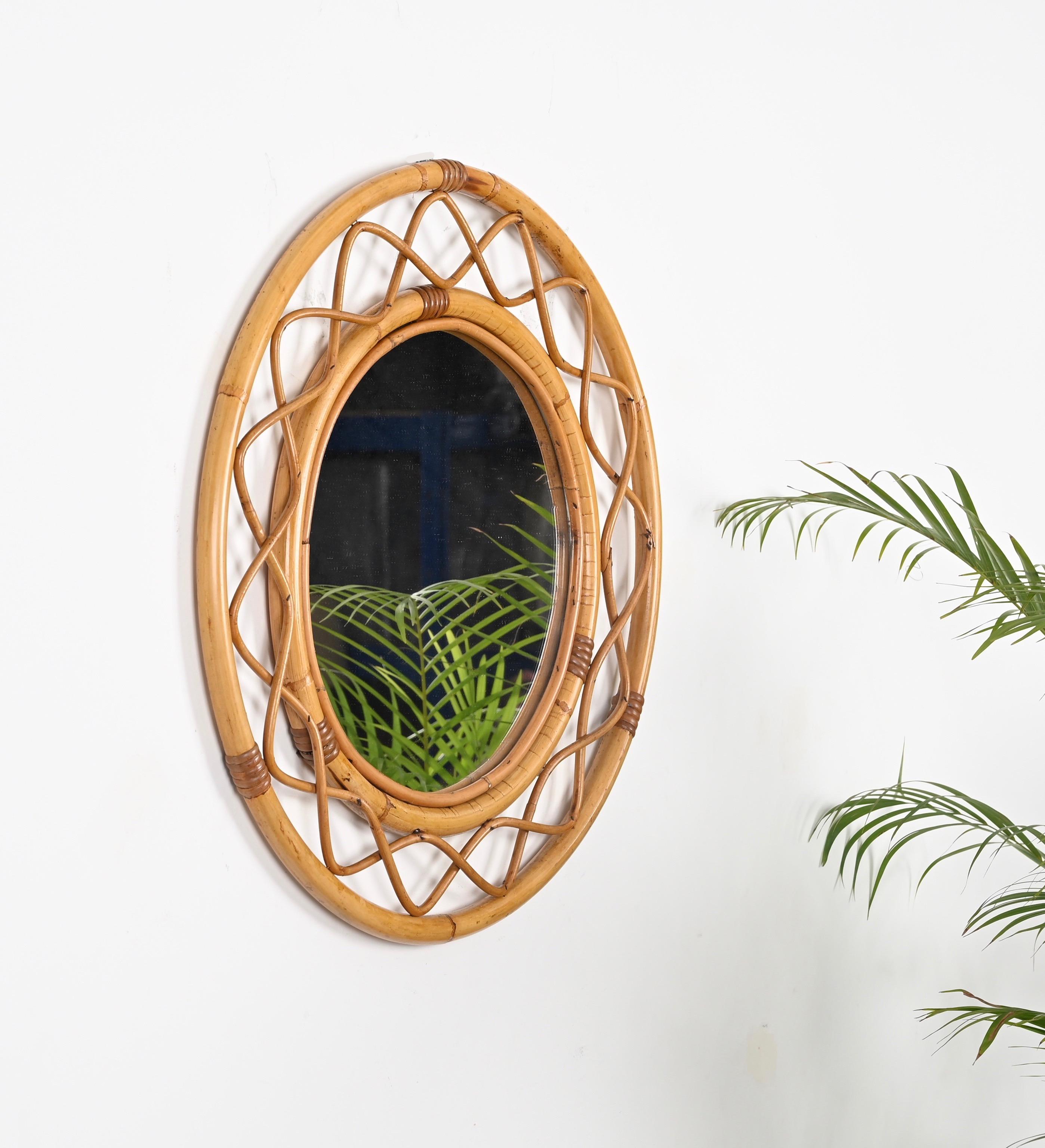 Superbe miroir rond de style Côte d'Azur du milieu du siècle, entièrement fabriqué en bambou, rotin et osier. Ce charmant miroir organique a été fabriqué à la main en Italie dans les années 1960. 

Ce superbe miroir présente un double cadre rond en