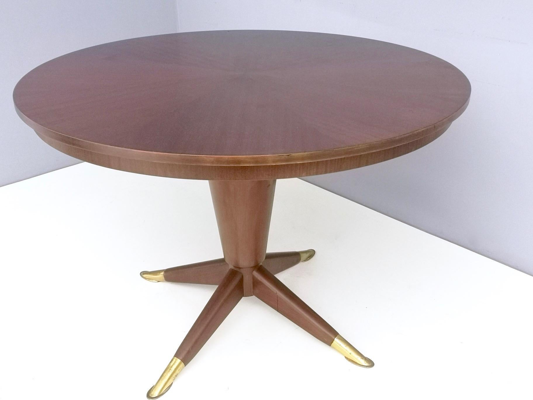 It's made in mahogany and features brass feet caps. 
It might show slight traces of use since it's vintage, but it can be considered as in excellent original condition and ready to become a piece in a home.

Diameter: 119.5 cm
Height: 81 cm
