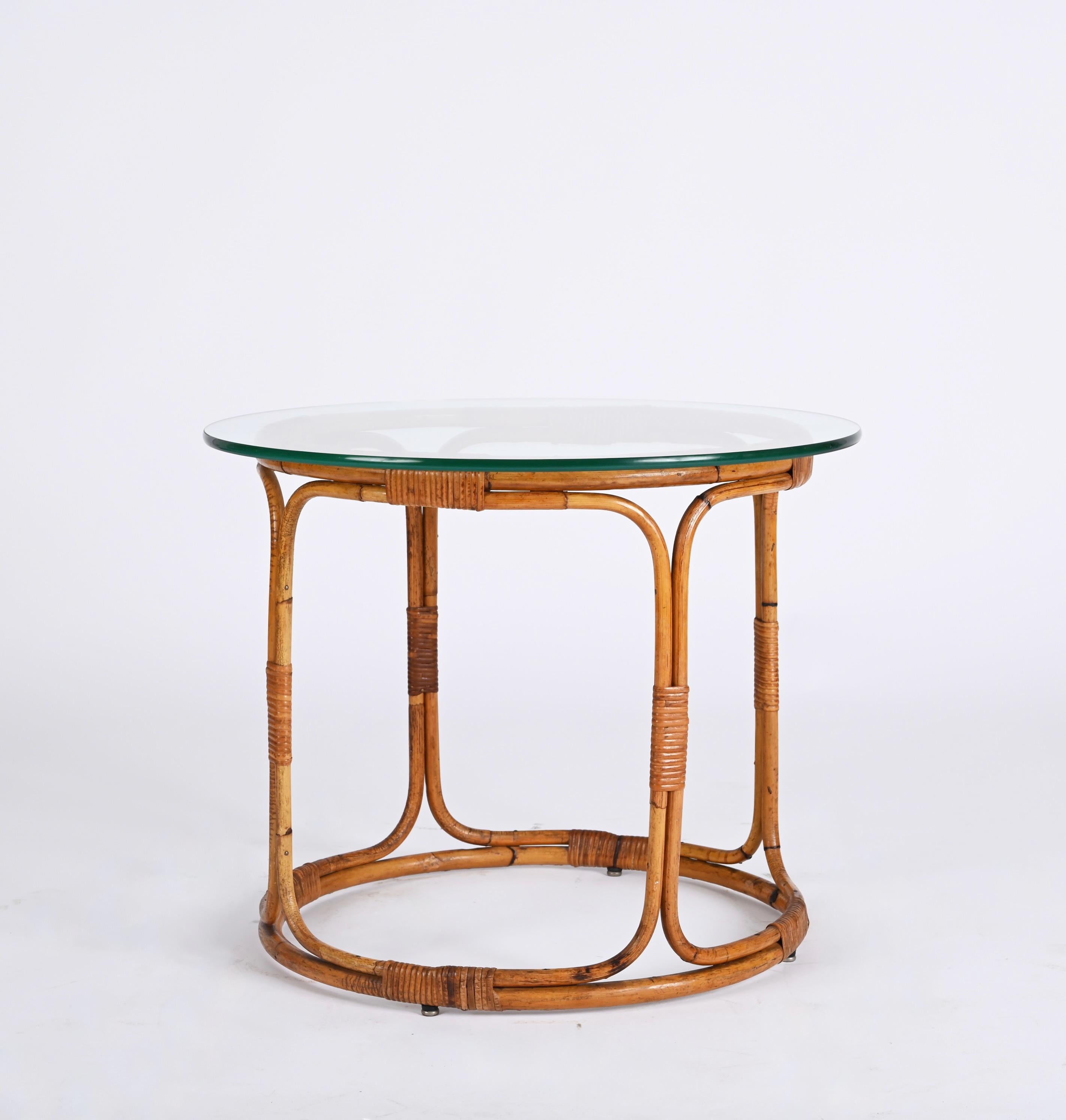 Stunning midcentury rounded coffee table in rattan and bamboo with glass and metal feet. This wonderful bamboo and rattan coffee table was produced in Italy during the 1960s in French riviera style, following François Rivière's steps. 

This item