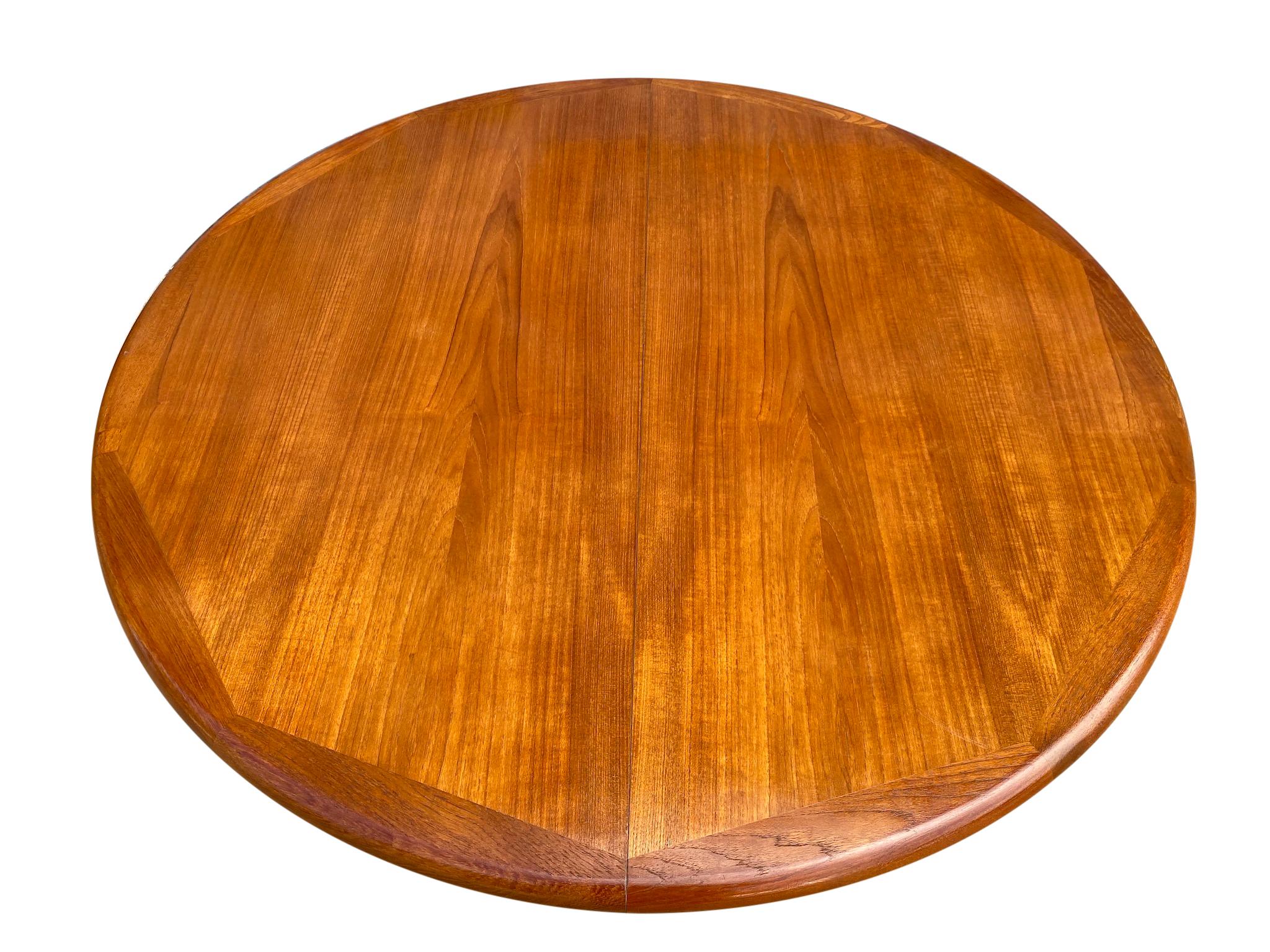 Midcentury solid teak Danish extension dining table with (2) leaves. This table is very high quality hand built by CJ Rosengaarden Hojre. Solid teak legs with center base. This table is in great vintage condition, all (2) leaves match the table