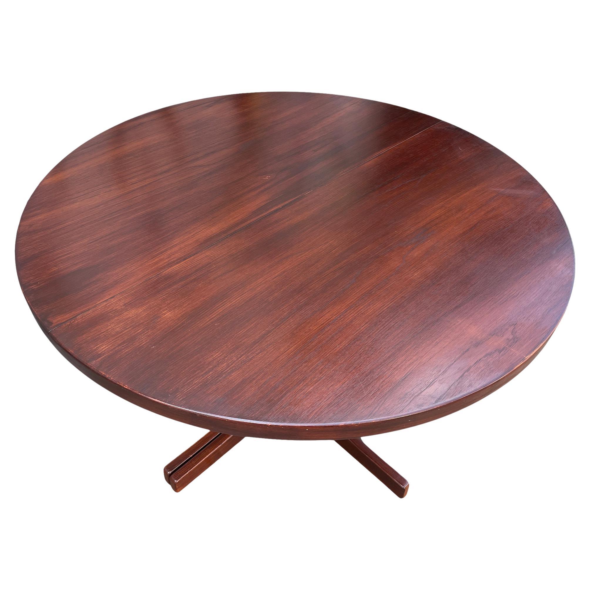 Midcentury teak round Danish Modern extension dining table with (2) leaves. This table has Solid curved flat wood legs and the table is in great vintage condition. Both leaves match the tables finish 100% - table Comes with (2) leaves total.