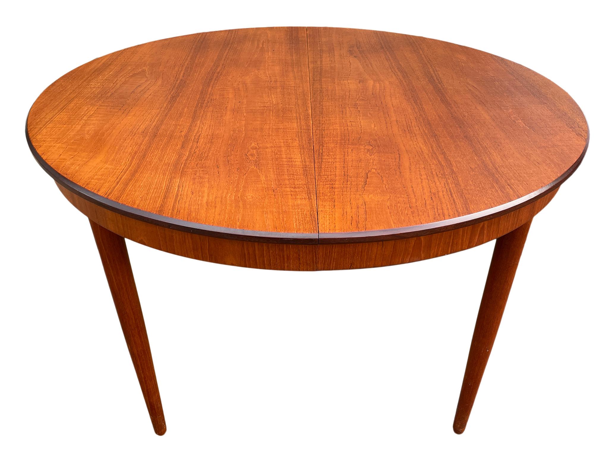 Midcentury teak round Danish Modern extension dining table with (3) leaves. This table has Solid teak legs that unscrew by hand. This table is in great vintage condition, (1) leaf with matches the table 100% and has an apron. Comes with (2) extra