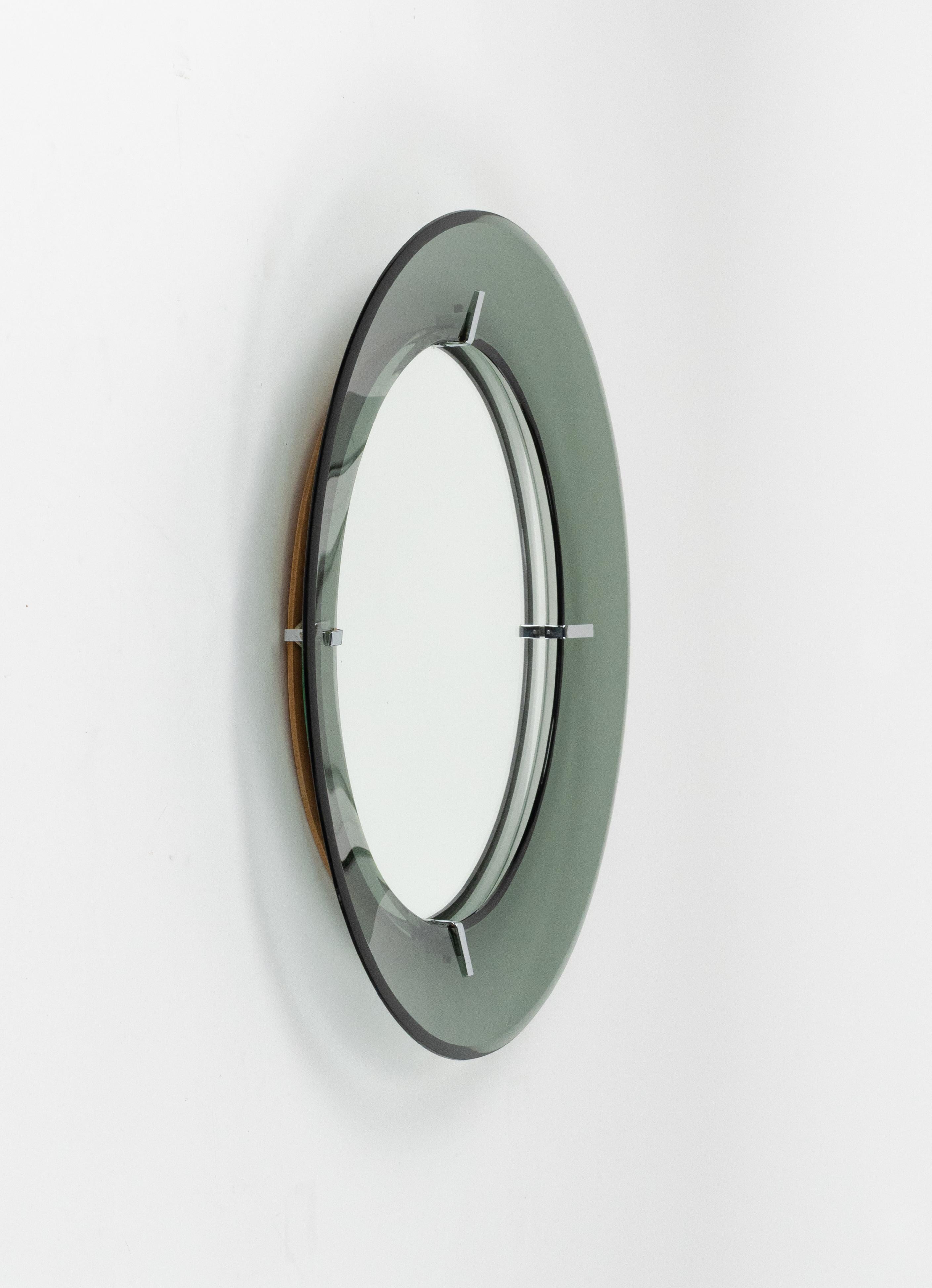 Midcentury amazing round wall mirror by Luigi Fontana for Fontanit.

The mirror is made of a concave, green glass frame with the mirror in the centre.

Made in Italy in the 1950s.

The original label is still attached as shown in the pictures.