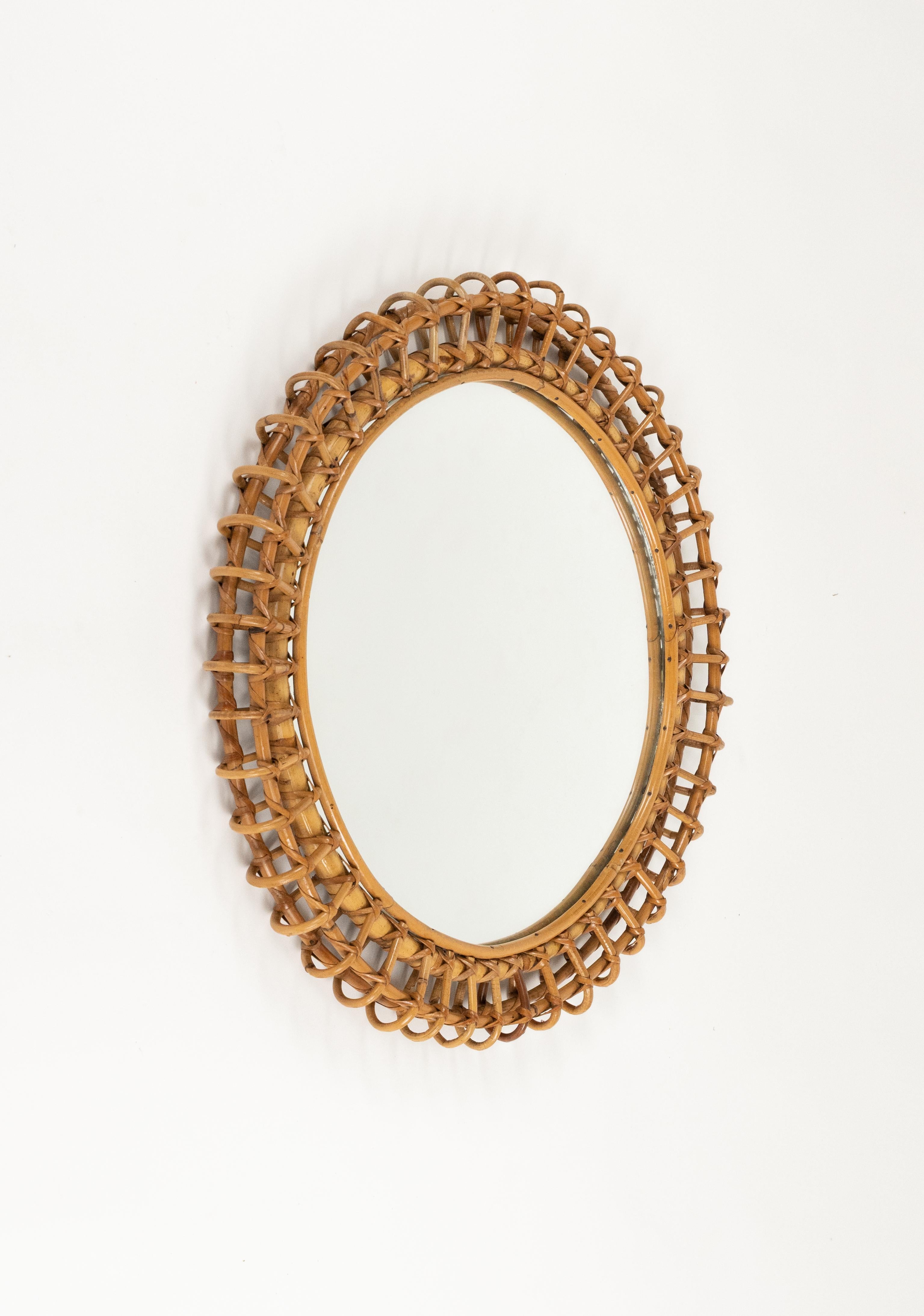 Midcentury beautiful round wall mirror framed in bamboo and rattan in the style of Franco Albini.  

Made in Italy in the 1960s.

A highly decorative bamboo and rattan mirror with the taste of the Mediterranean Coast style.
