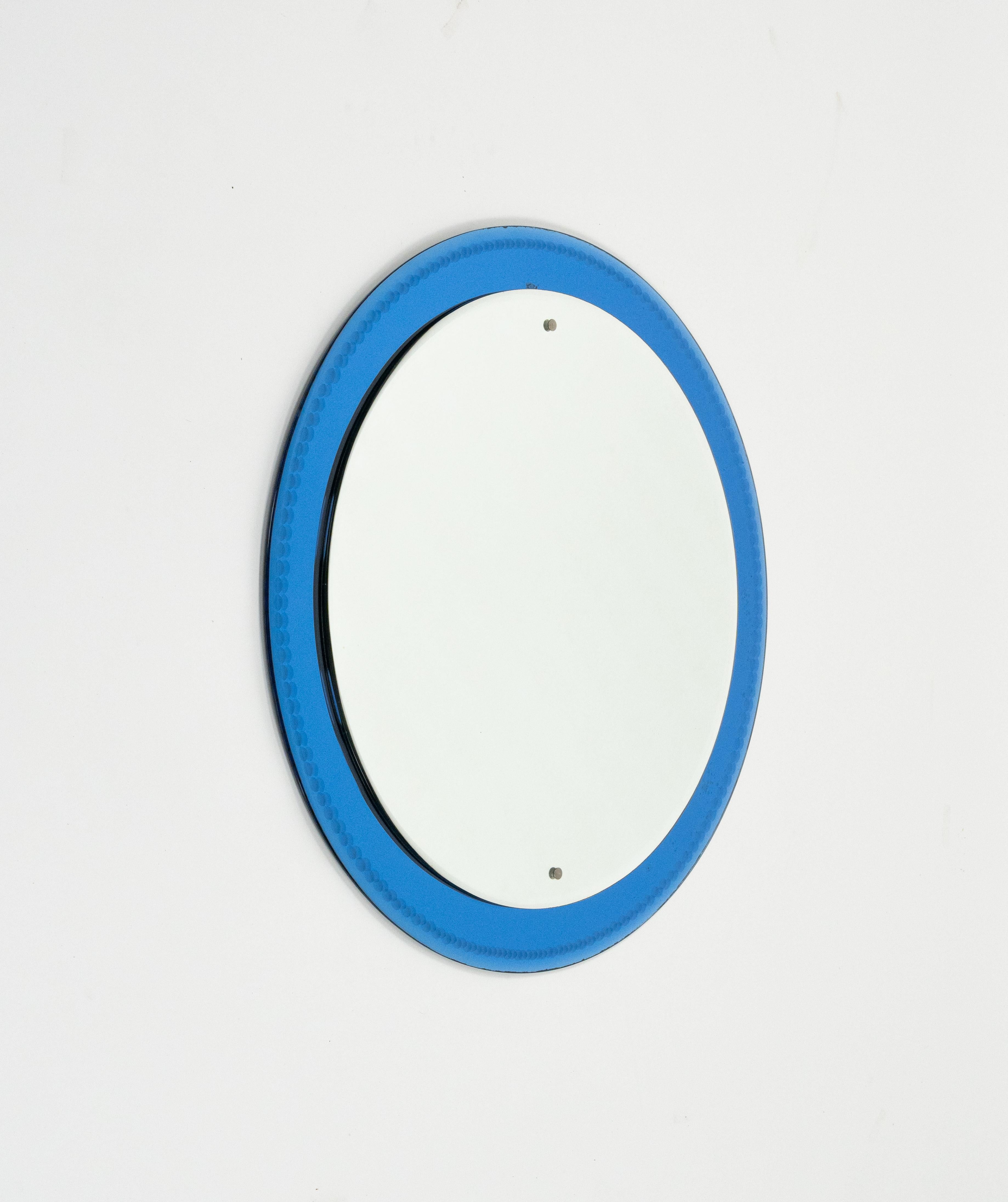 Midcentury amazing round wall mirror with blue glass frame and metal details in the style of Fontana Arte.

Made in Italy in the 1960s.
