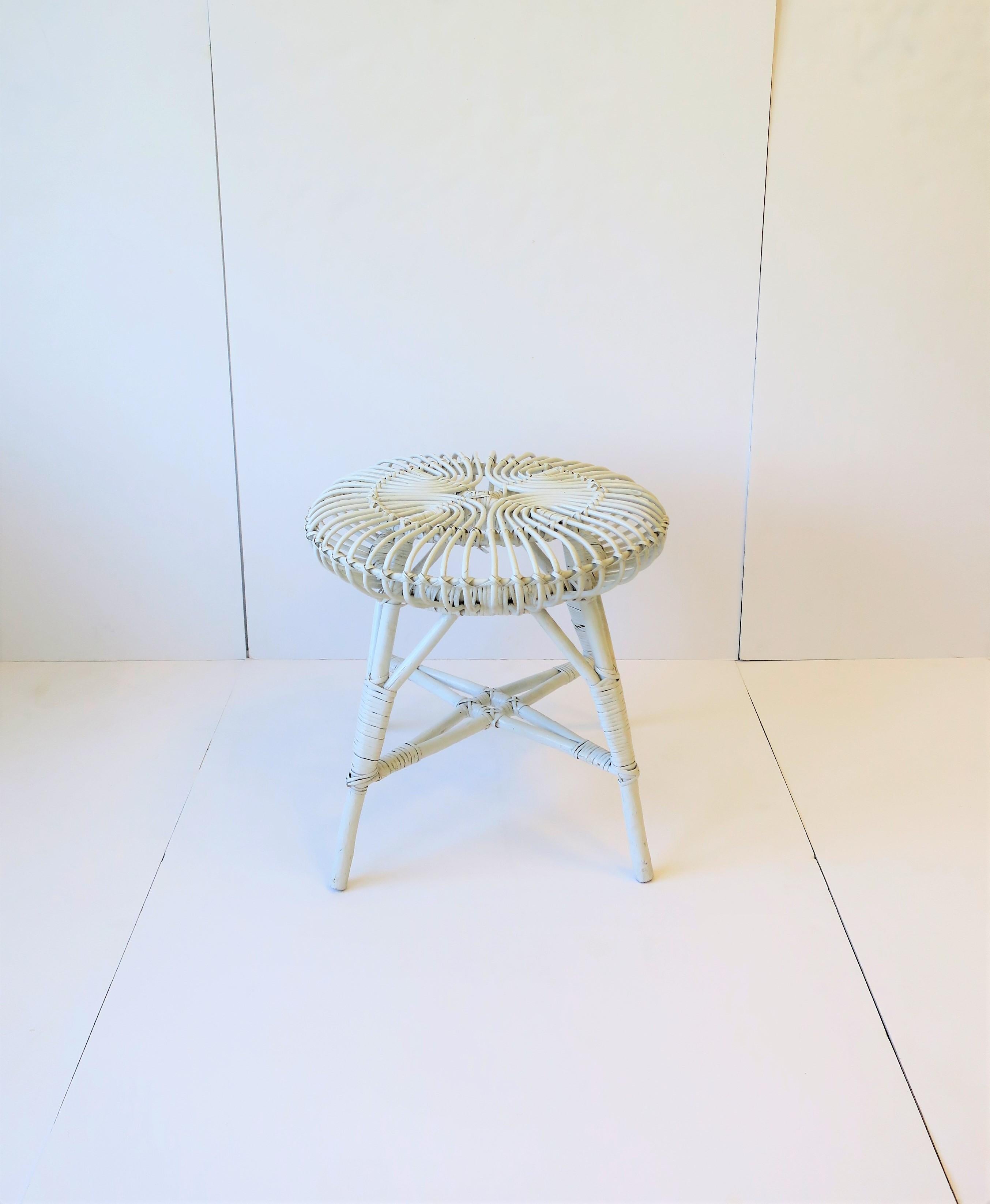 A round white wicker rattan stool in the style of Italian designer Franco Albini, Midcentury Modern design period, circa mid-20th century, perhaps from Europe/Italy. Piece works as a stool, footstool, or as a side/drinks table providing there's a