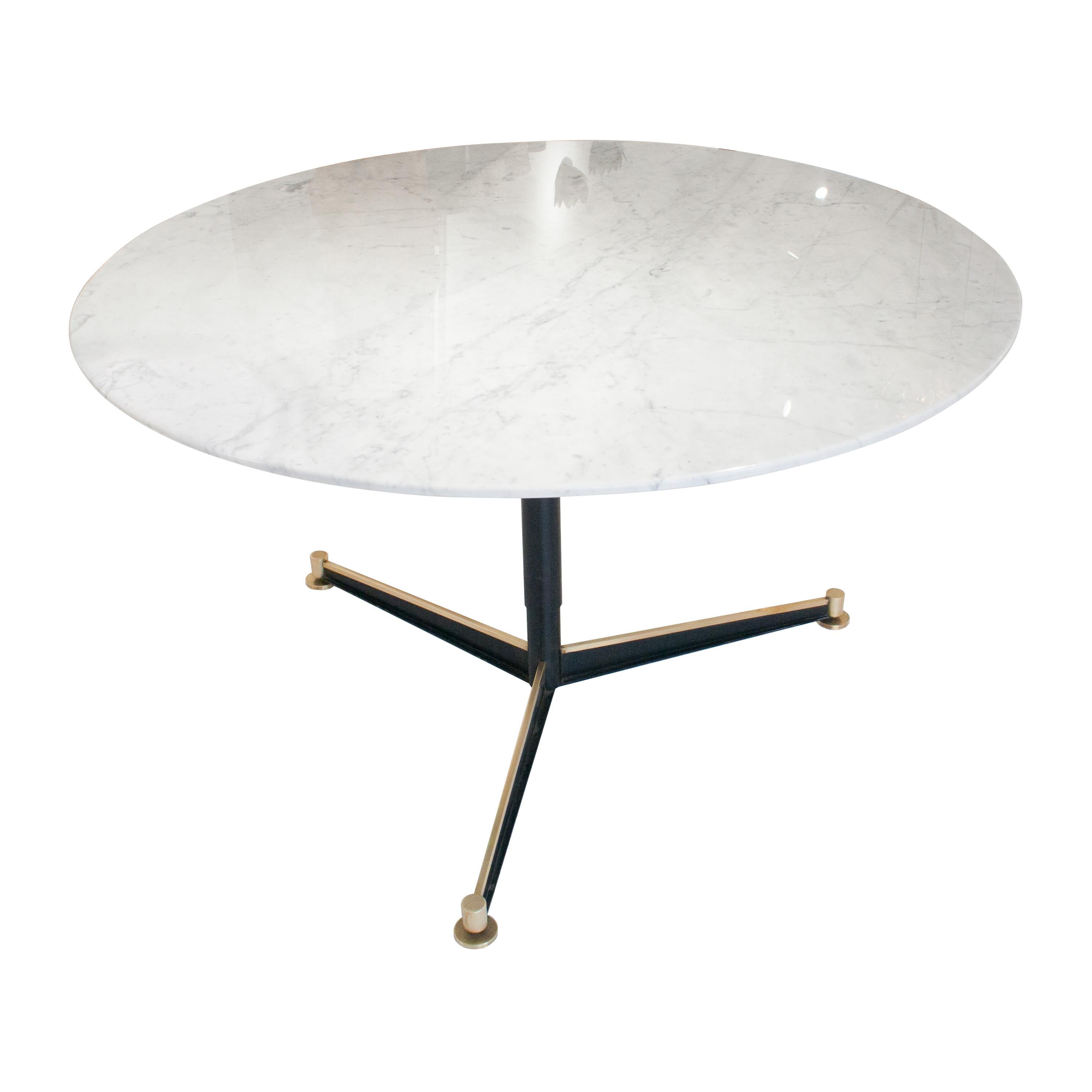 Round dining table with Carrara marble-top and metal foot with black lacquered three feet base, embellised with brass details and with height adjustable pads.