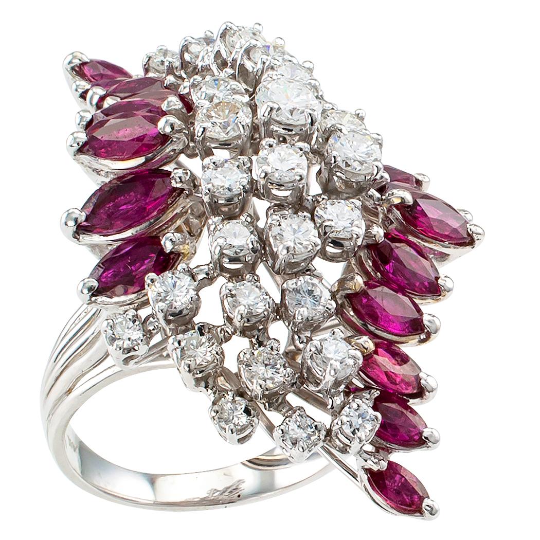 Midcentury ruby and diamond white gold cocktail ring circa 1950. The slightly domed, navette-shaped design plays on the symmetry between a cluster formed by thirty-three round brilliant-cut diamonds totaling approximately 1.90 carats, approximately