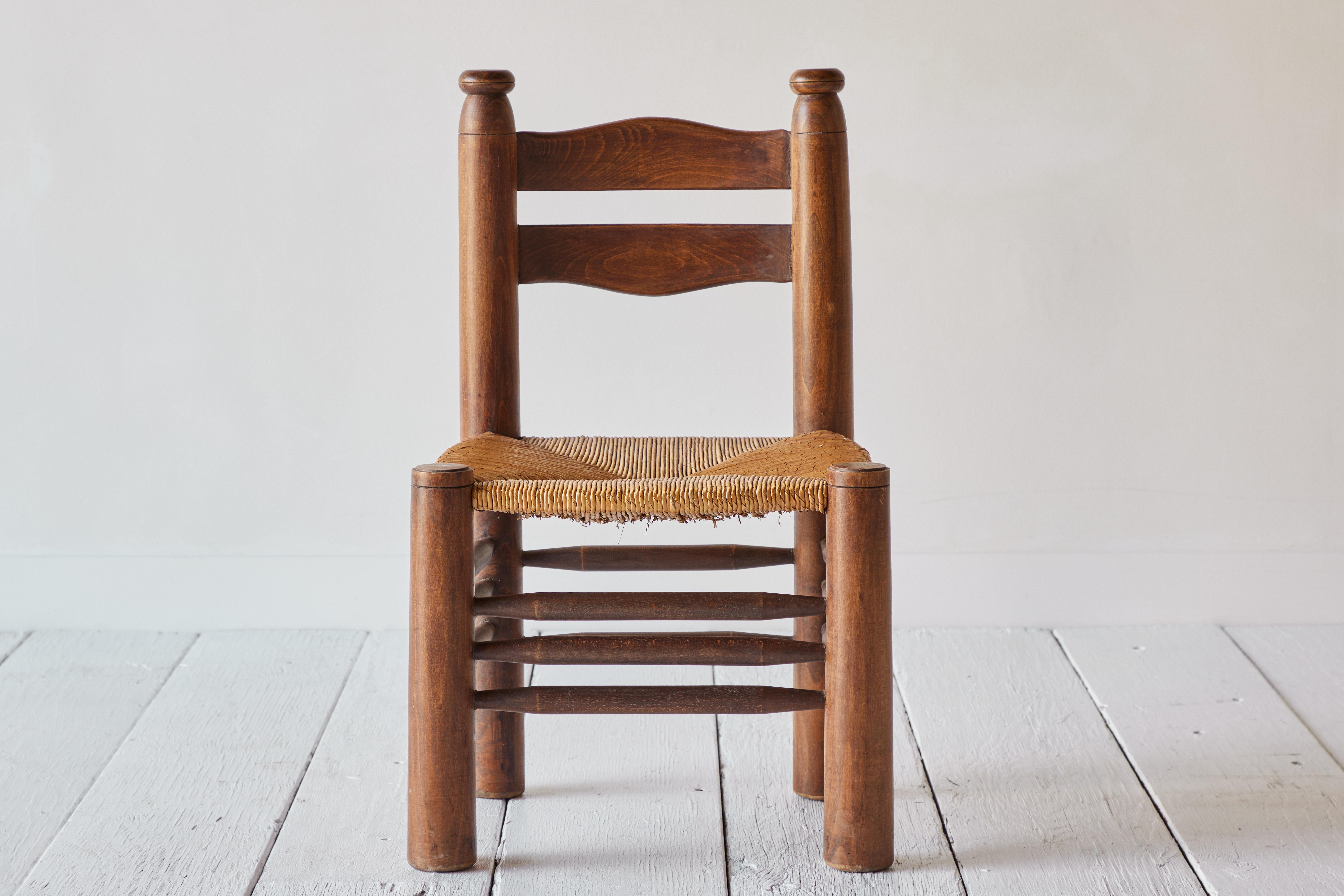 A wood rush chair in the manner of Charlotte Perriand's children’s chairs, circa 1950. We love the proportions of this chair and three stretchers between each leg. This chair is sound and solid in good vintage condition with minor signs of use and