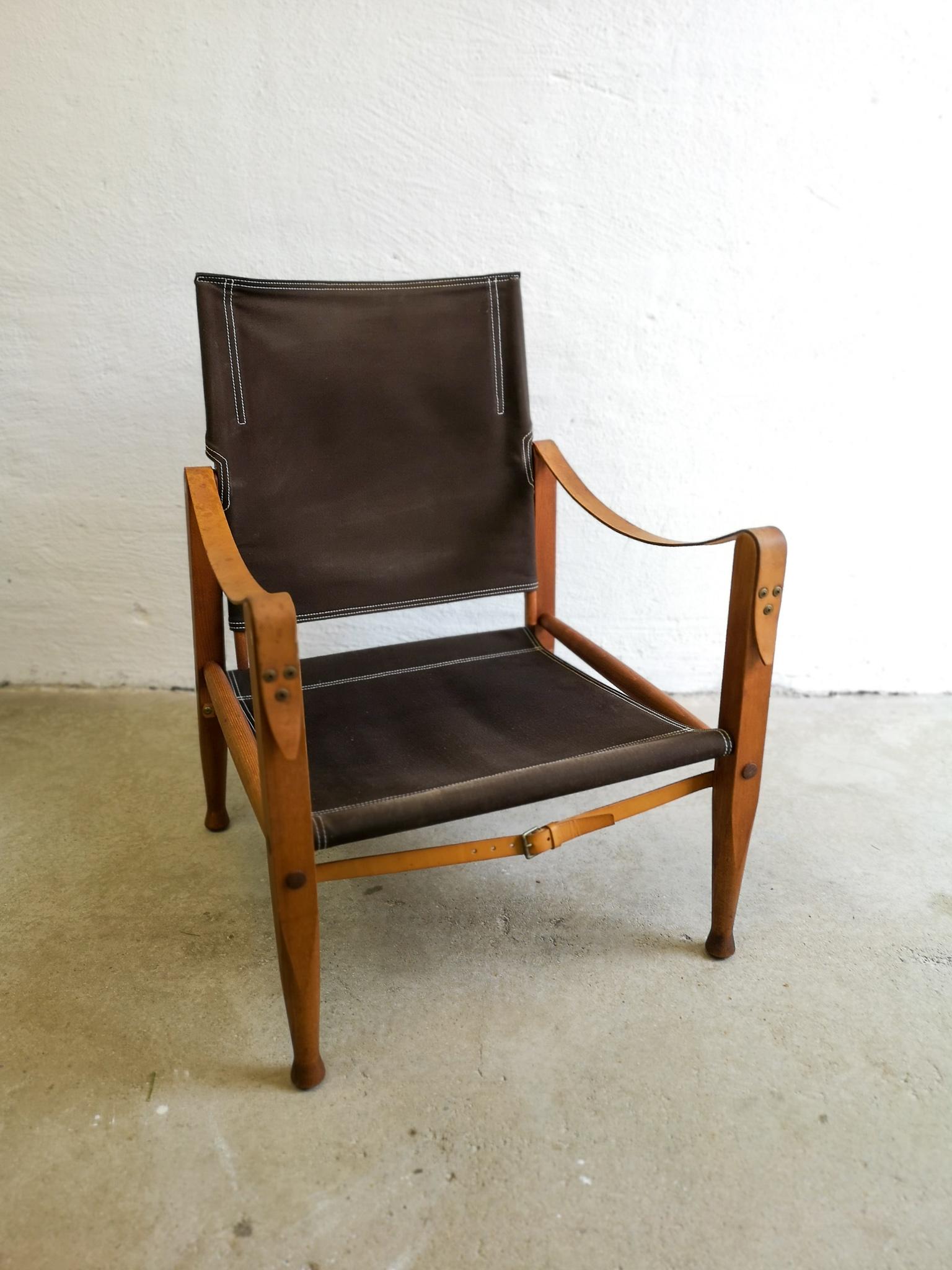 This edition of the very famous safari chair was produced in Denmark at Rud Rasmussen and designed by Kaare Klint. The lounge chair is made in canvas, leather and oak. 

Good vintage condition with wear and patina on both the canvas and on the