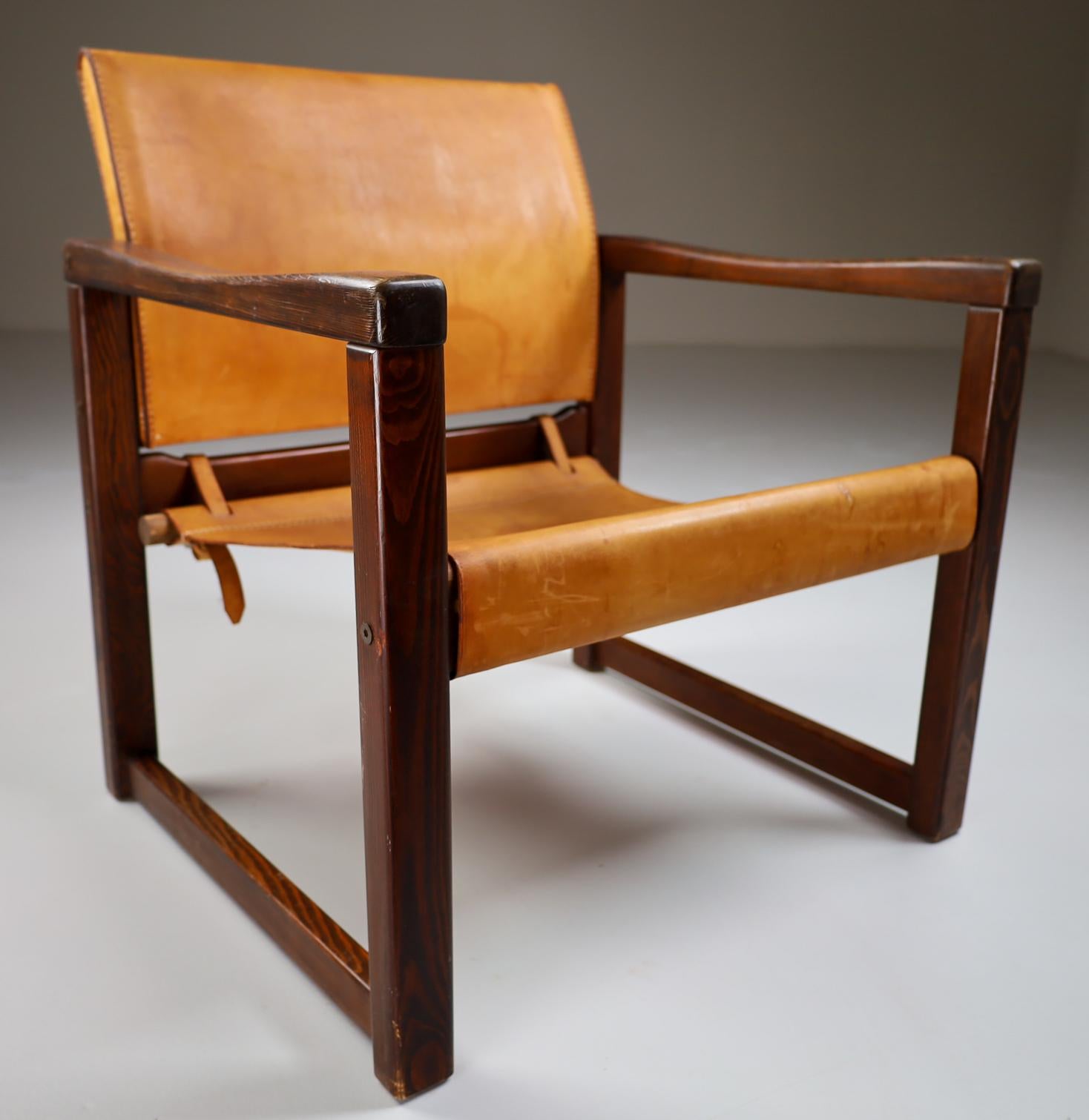 Safari lounge chair in absolutely gorgeous patinated cognac saddle leather and solid pinewood, circa 1970s. The thick saddle leather is beautifully patinated during use and age and shows interesting stitching. European Pine wood with thick saddle
