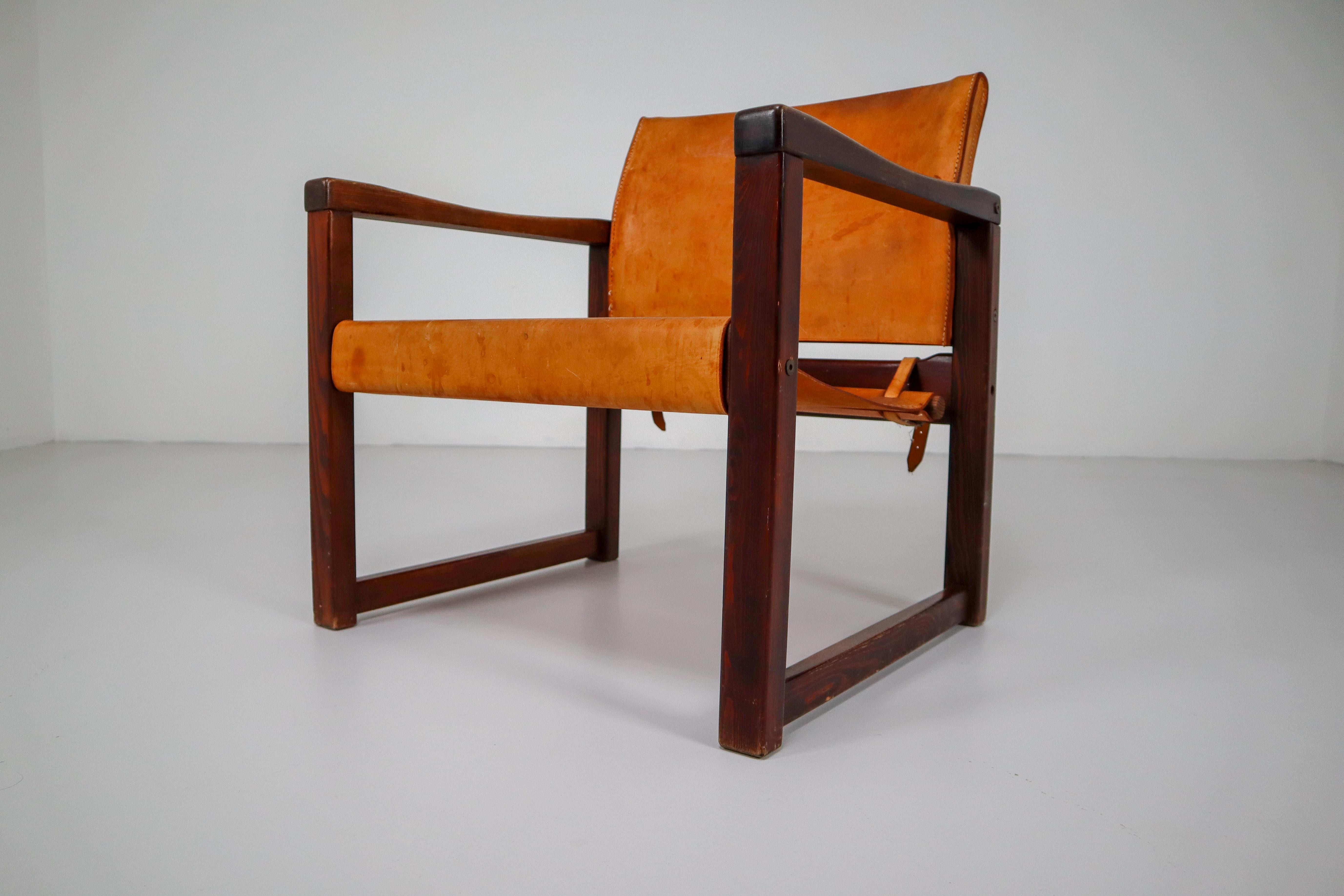 Safari lounge chairs in absolutely gorgeous patinated cognac saddle leather and solid pinewood, circa 1970s. The thick saddle leather is beautifully patinated during use and age and shows interesting stitching. There is a color difference between