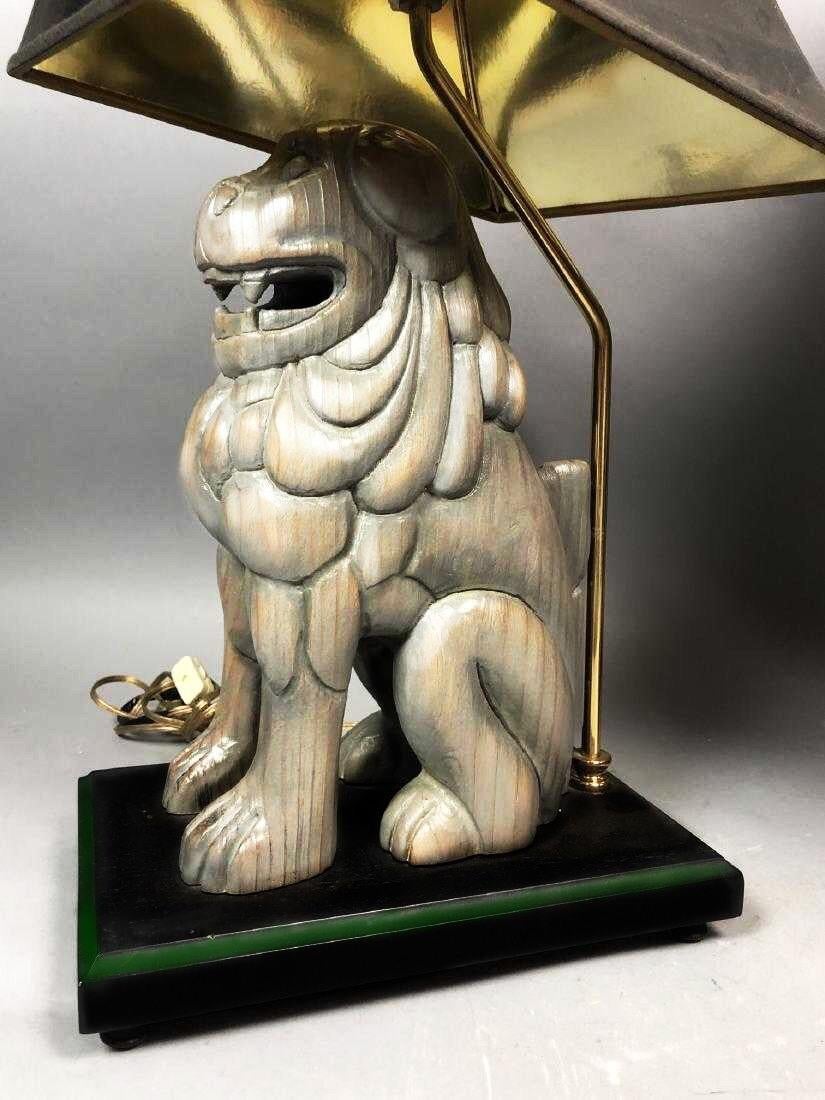 A stunning pair of highly stylized foo dog table lamps by Sarreid Ltd. of Spain, circa 1960. Hand carved solid wood form with exceptional detail. Forged brass shaft and finial. Subtle glazed finish. Heavy and beautifully made. Complimentary