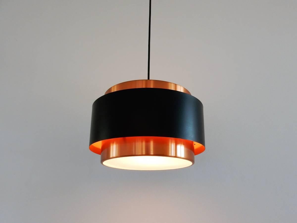 This Saturn pendant lamp is made of brass and black lacquered metal, combined with white plexiglass where the light shines through beautifully. It is in a very good condition with some smaller signs of age and use.