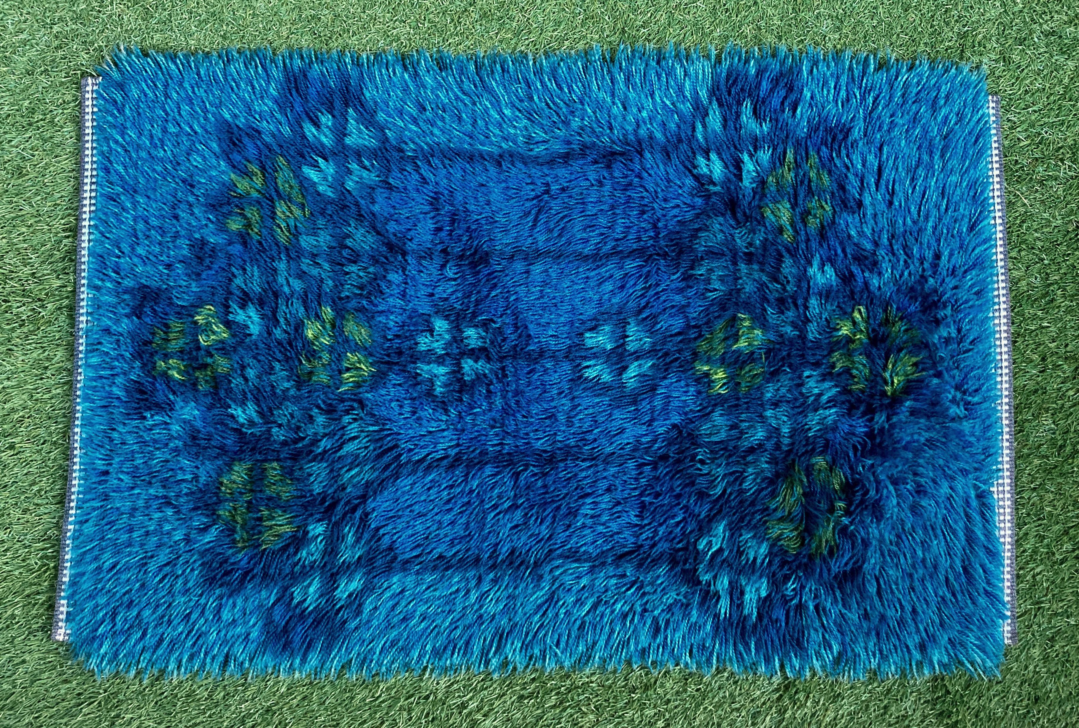 A silky midcentury high pile Scandinavian rya rug or wall hanging dating, circa 1960s. The vintage rug was crafted from hand knotted wool in several shades of blue with yellow and green accents creating a pattern with strong secessionist and Celtic