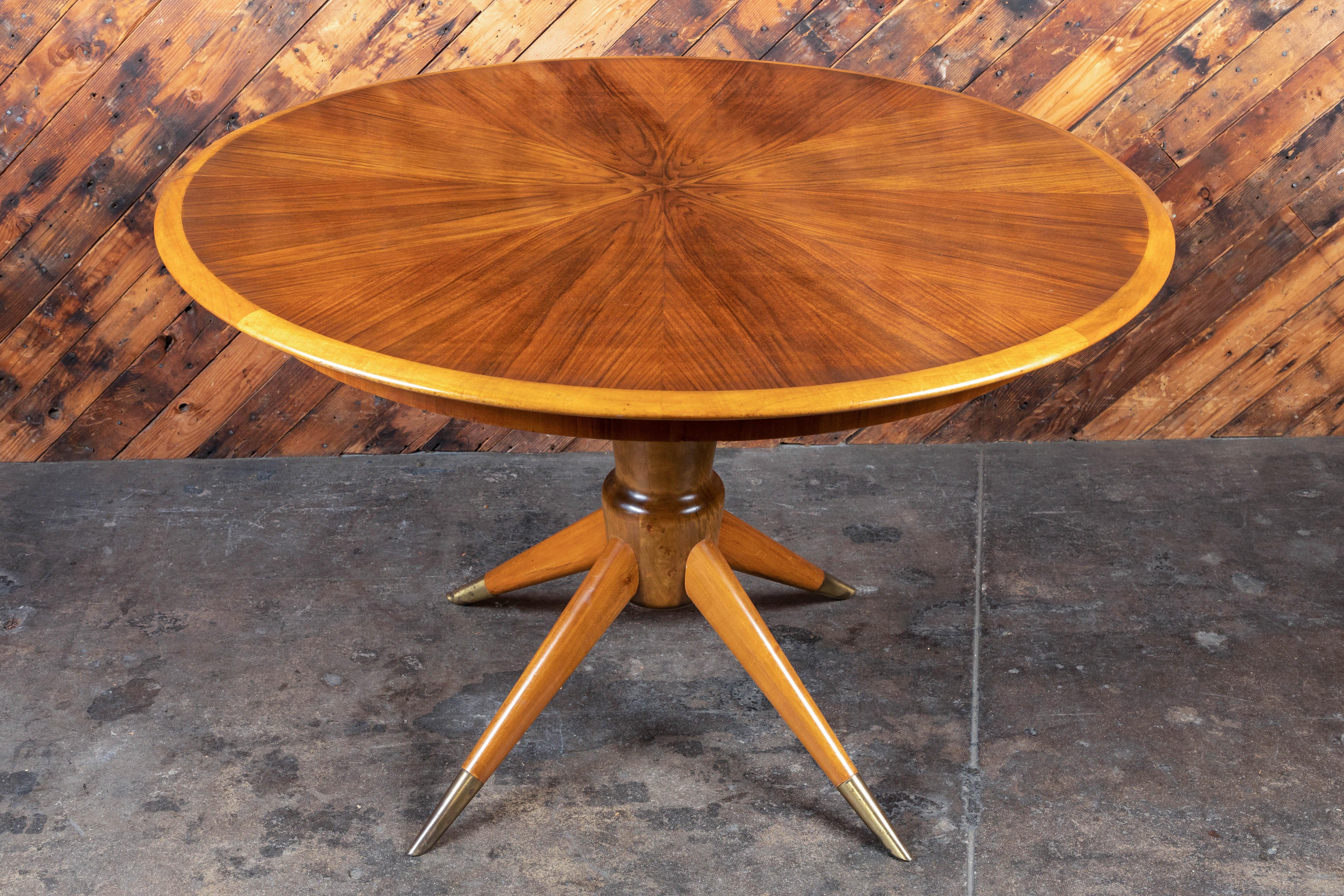 Features pedestal base with long brass tipped feet. Gorgeous grain, extends from round top to long oval with two leaves. Great designed flip down support legs tuck into the table. 

Measures: Diameter 46, height 29

Two leaves: 18 D each.