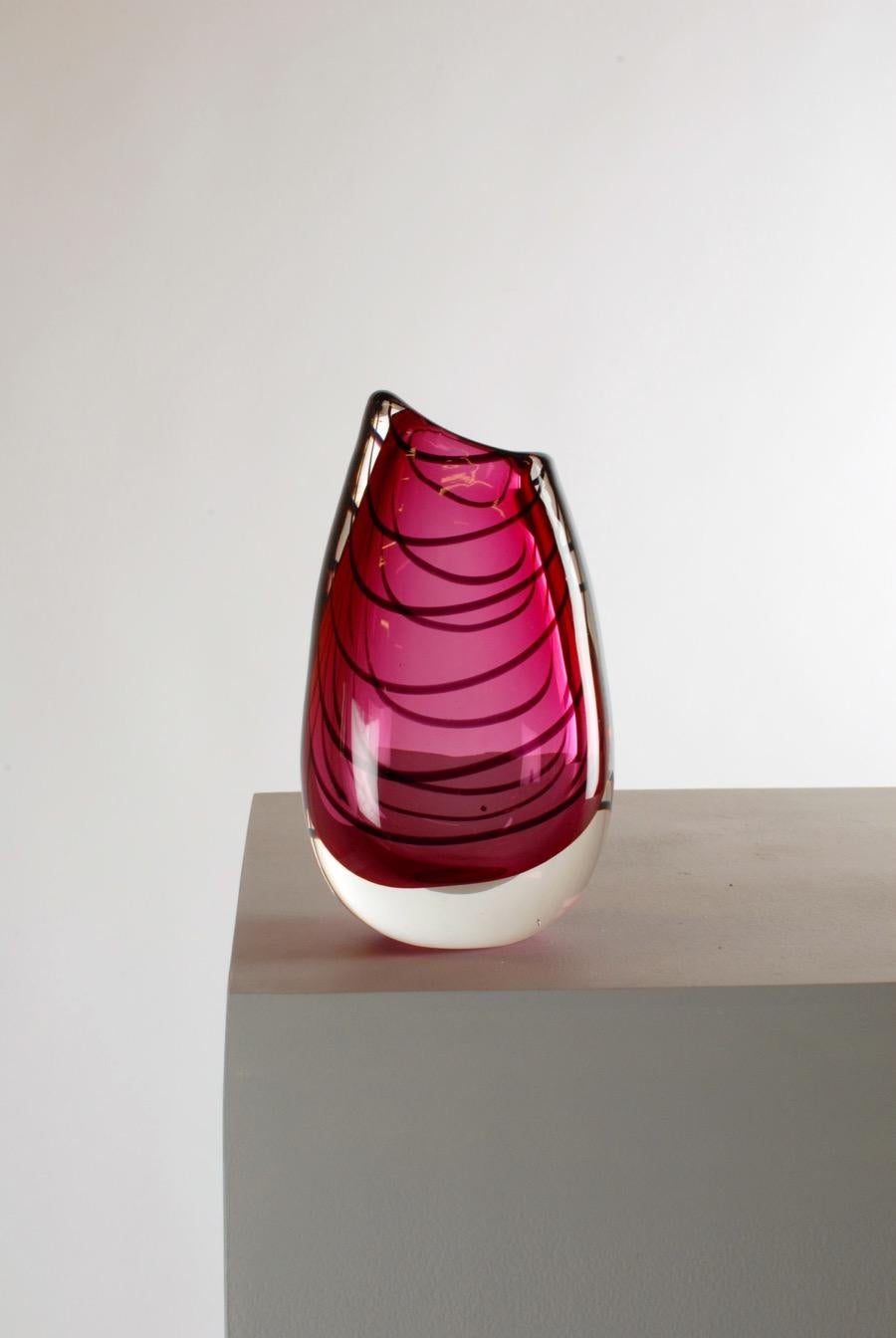 Midcentury Modern Scandinavian glass vase manufactured by Magnor Norway.
Small production rare vase serie by the renknown Norwegian manufacture.
Two colored Pinkish red ground color with black brown thread like detail and clear base,
circa