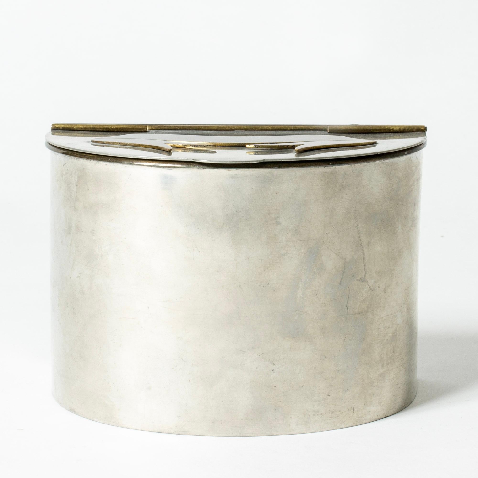 Lovely pewter jar by Estrid Ericson, in a sleek form adorned with a brass bow on the lid.