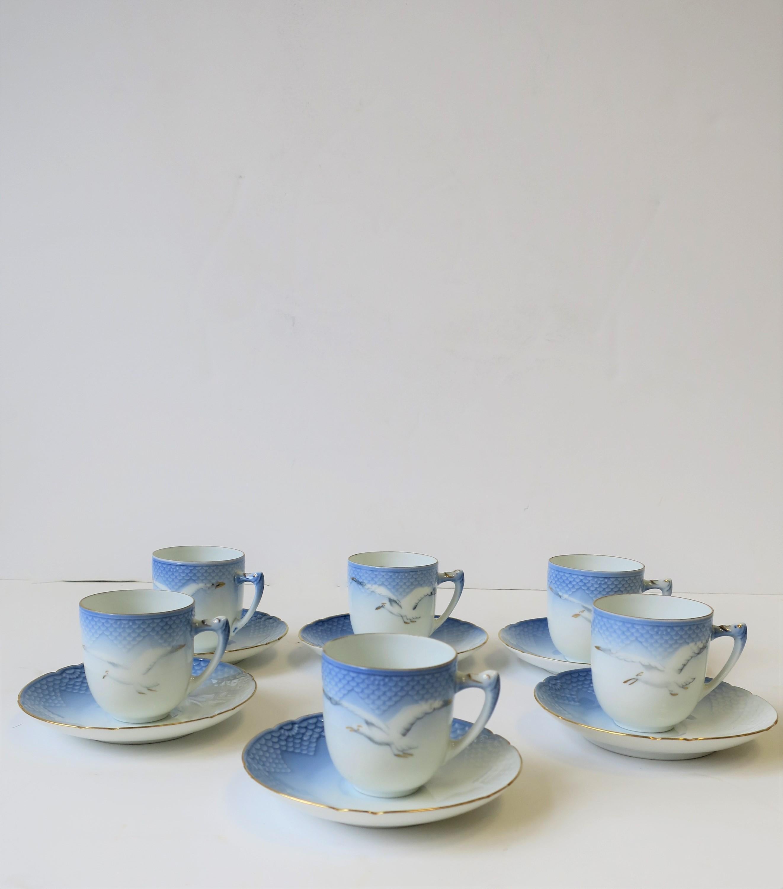 A beautiful set of six (6) Scandinavian Danish porcelain coffee espresso or tea demitasse cups and saucers with bird design by Bing & Grondahl, circa mid-20th century, Denmark. Pieces are blue and white with gold accent; cups feature a bird in