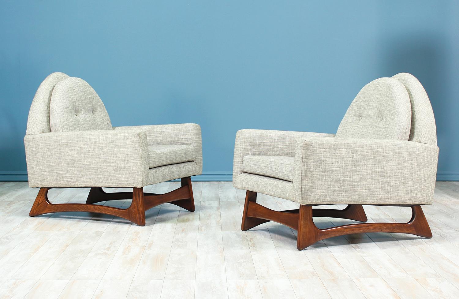 A pair of lounge chairs designed by Adrian Pearsall for Craft Associates in the United States circa 1960s. These lounge chairs feature a sculpted walnut wood base with solid stretchers that create a durable foundation for lasting comfort. The loose
