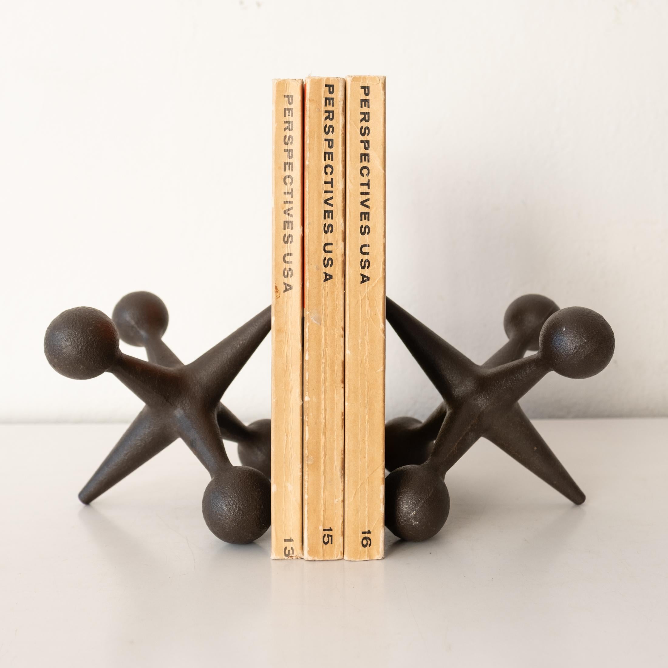 Solid iron sculptural jacks bookends in a chocolate brown. Could also be used as doorstops. 1950s.
 