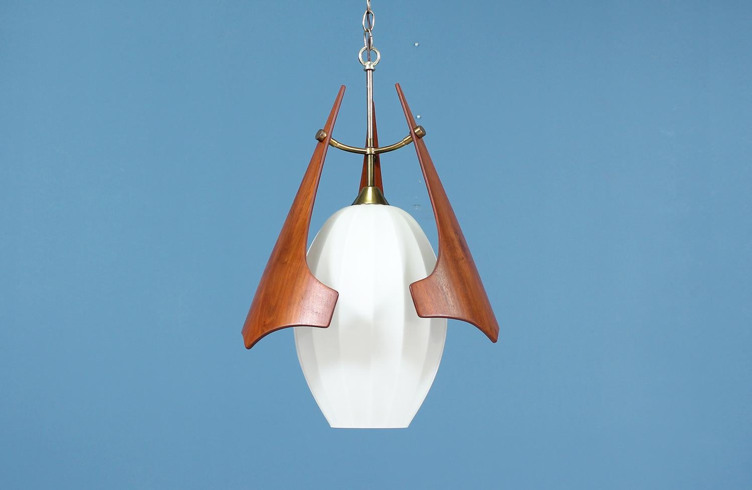 Stunning pendant chandelier designed and manufactured in the United States circa 1960’s. While maintaining its original pieces, this elegant pendant features a frosted glass surrounded by three newly refinished sculptural walnut wood pieces that