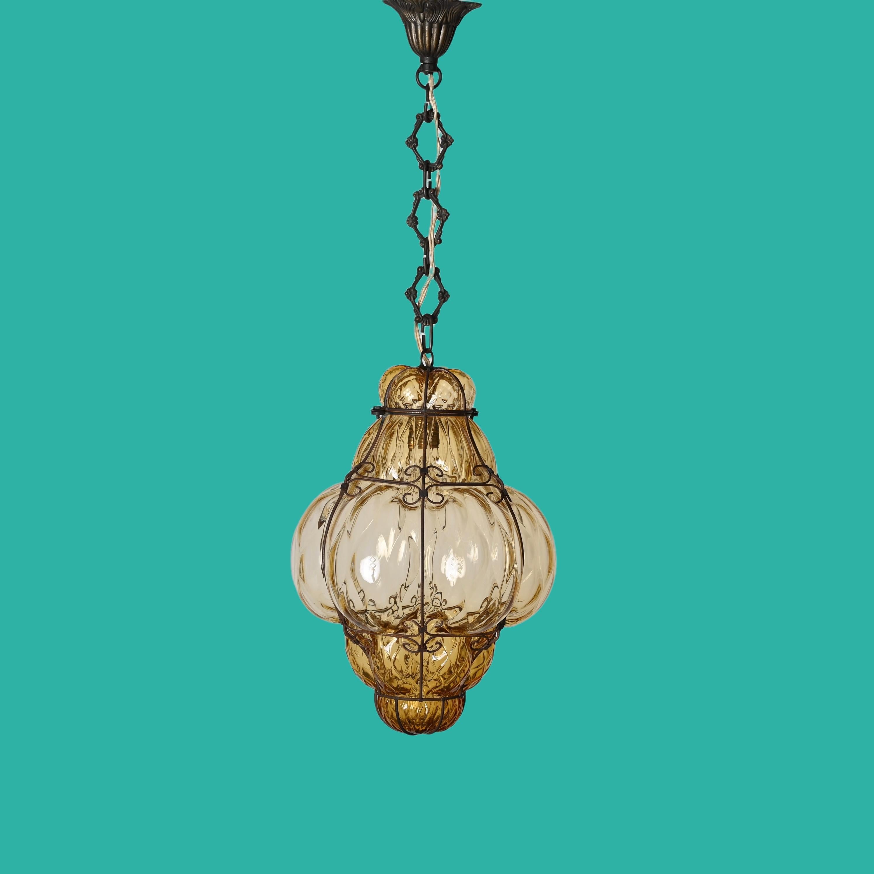 Beautiful large bubble chandelier in Murano glass with amber glass and iron cage. Giorgio Seguso created this glass is mouth-blown with an amber shade during the 1940s in Italy.

This Murano glass bubble cage pendant has an oriental style and