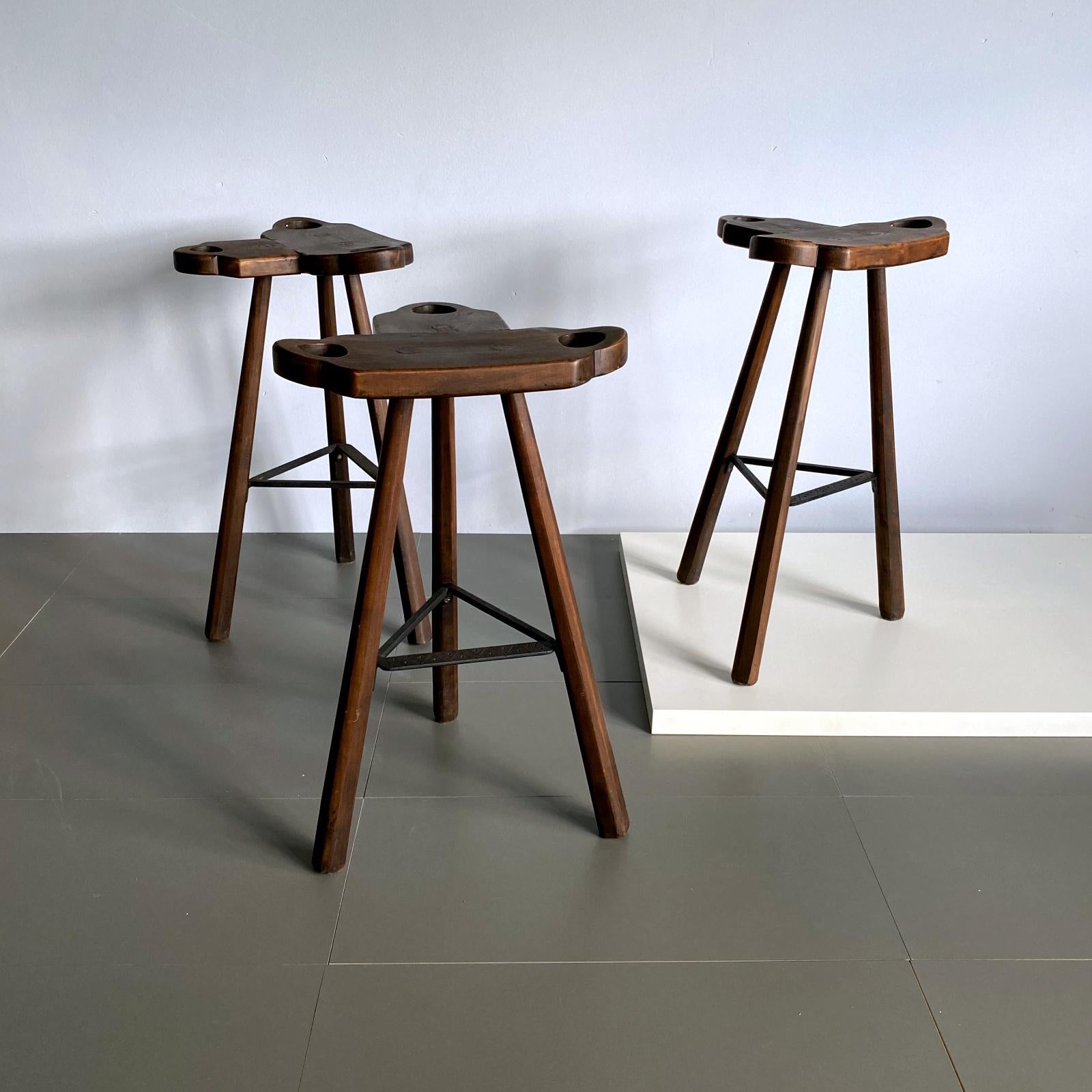 Three midcentury Marbella bar stools in stained oak wood with black steel patterned footrests. The curved T-shape seat makes the seating very comfortable. The three handles are very functional for moving on and off.

Measurements: 
H 77 cm / 30.3