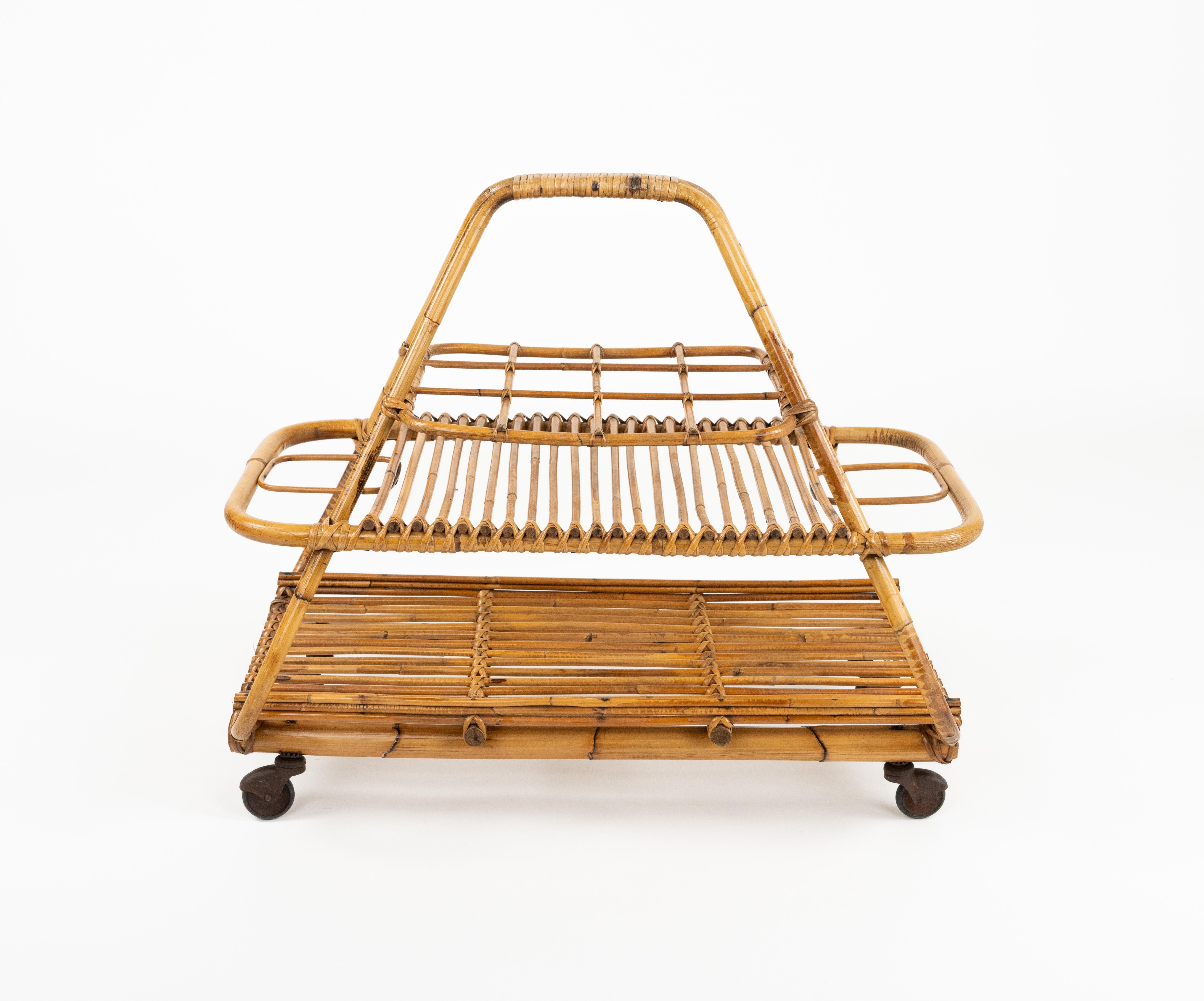 Midcentury amazing serving bar cart with bottle holder and glass holder with a curved handle for lifting in bamboo and rattan.

Made in Italy in the 1960s.