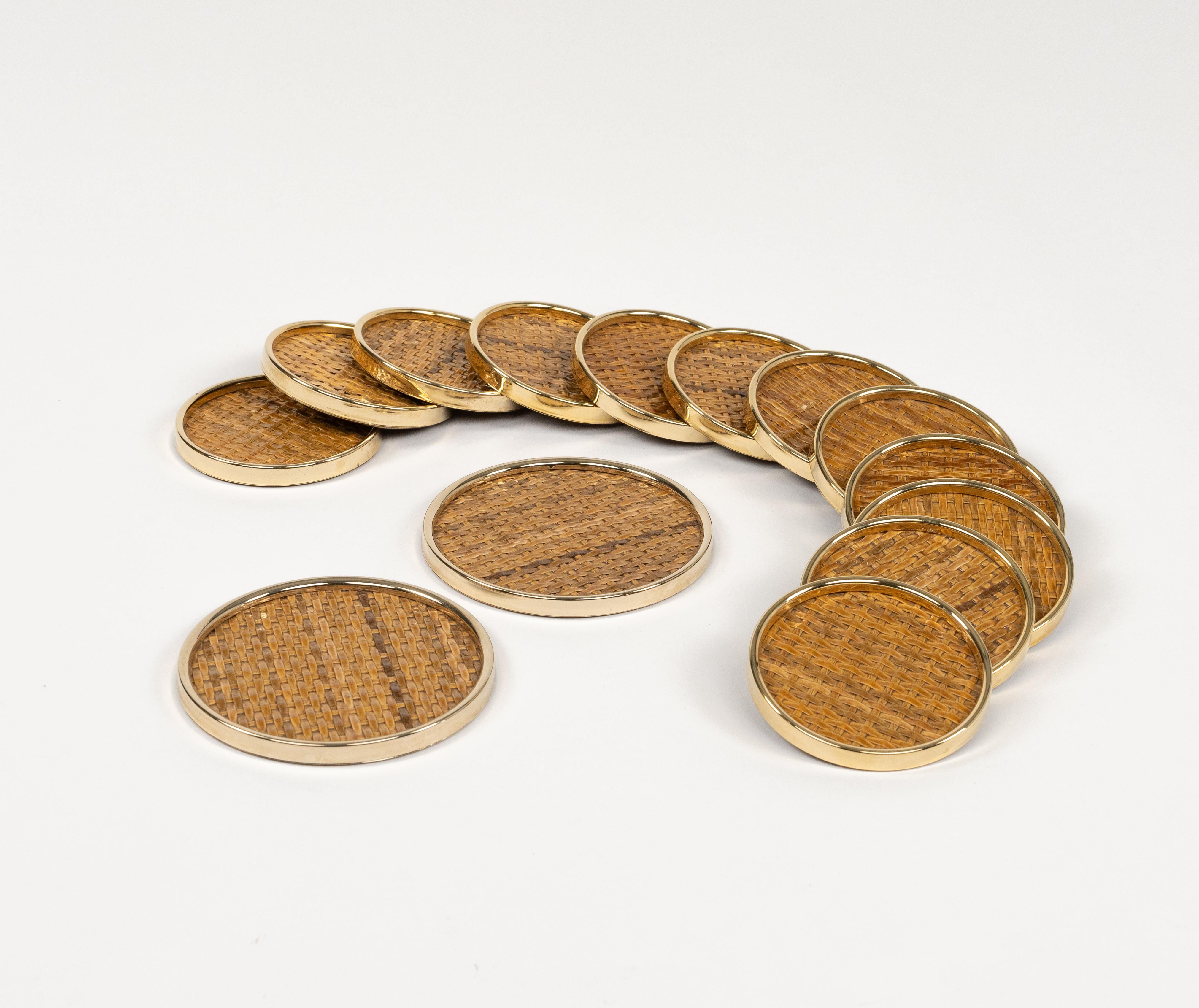 Midcentury beautiful set of 14 round coasters in brass and wicker in the style of Christian Dior Home.

Made in Italy in the 1970s.  

Dimensions: 
- 12 small size for glasses (diameter 9 cm)
 - 2 large size for bottles (diameter 12 cm).