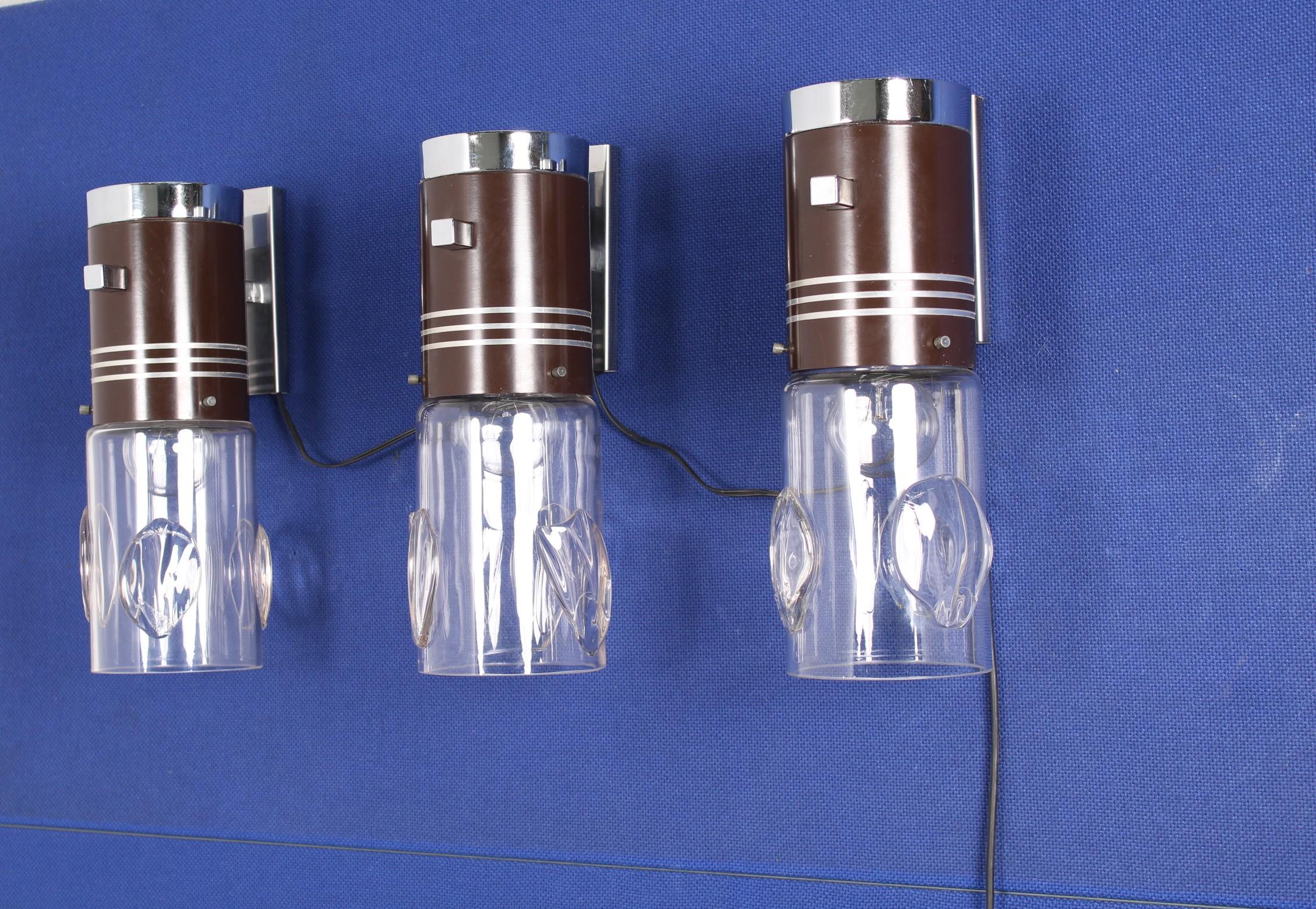 Three wall lamps in brown metal with Murano glass cups, Italy, 1970s
Wear consistent with age and use.