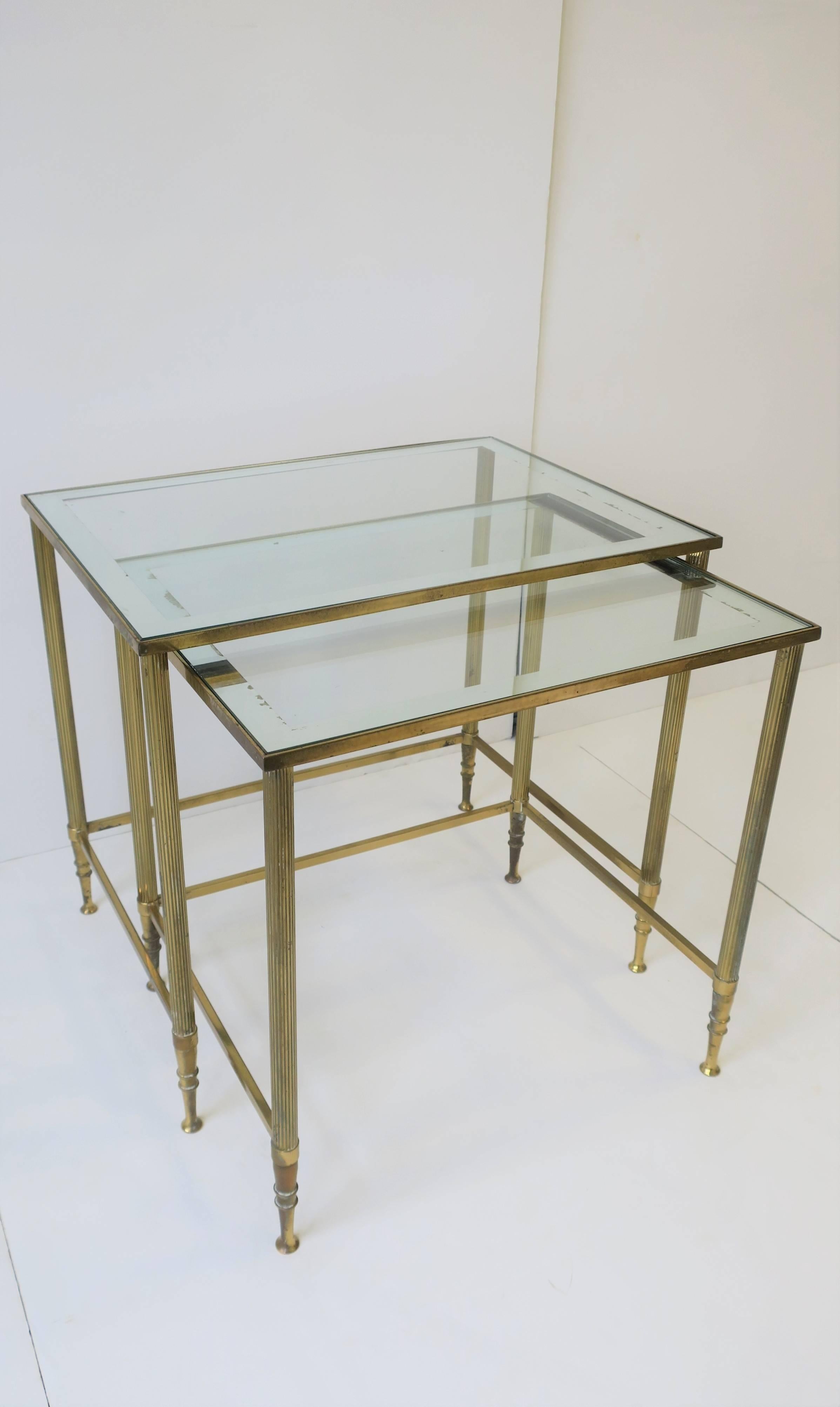 A versatile and substantial set/pair of Italian brass and glass nesting tables in the Directoire style, in the style of design house Maison Jansen, circa mid-20th century, 1960s, Italy. Tables can double as end tables, side tables, or cocktail