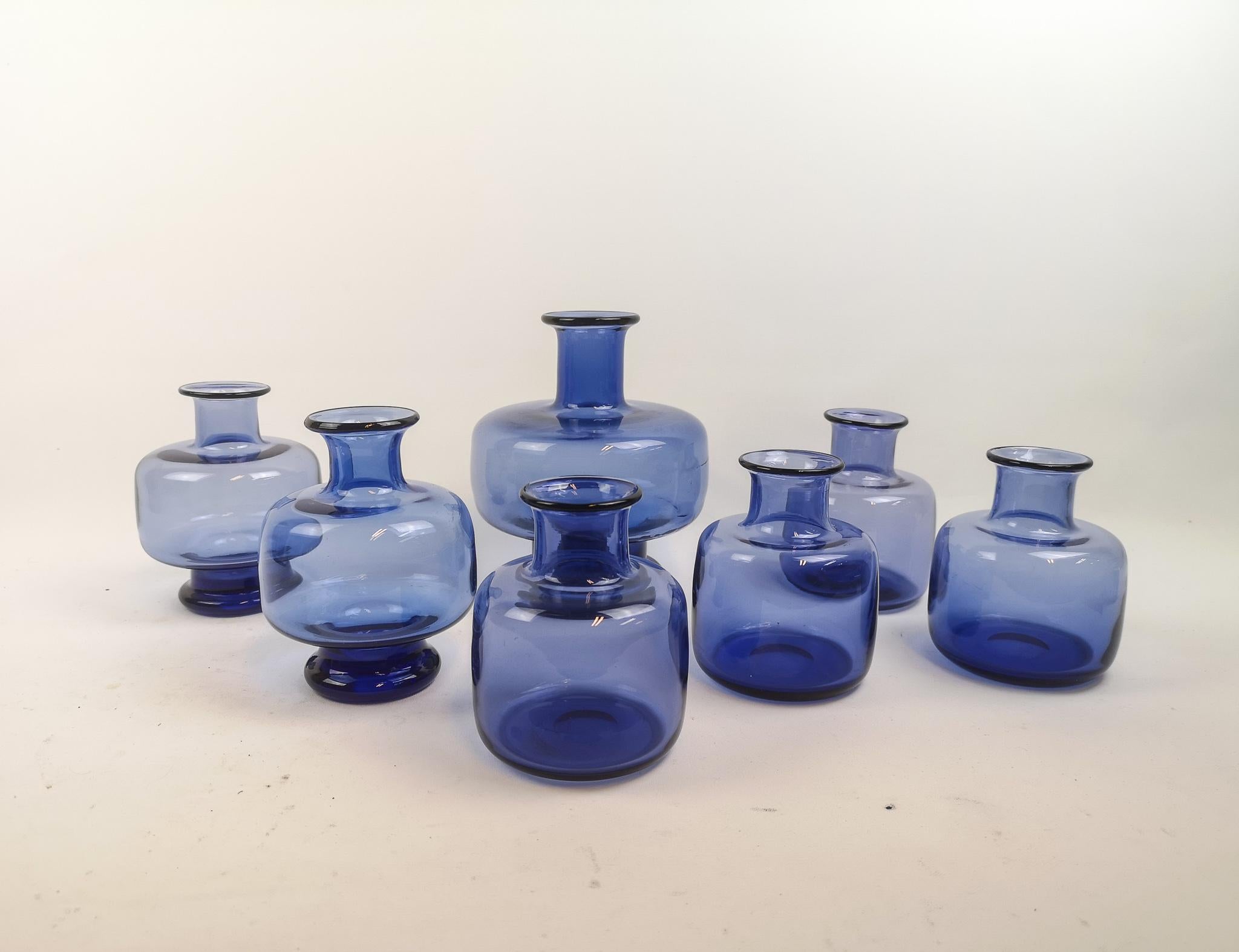 This set of seven small / medium vases in generous blue clear color, was produced by Danish company Holmegaard and designed by Per Lutken.

The set works wonderful together and can gives that extra to an atmosphere without taking too much