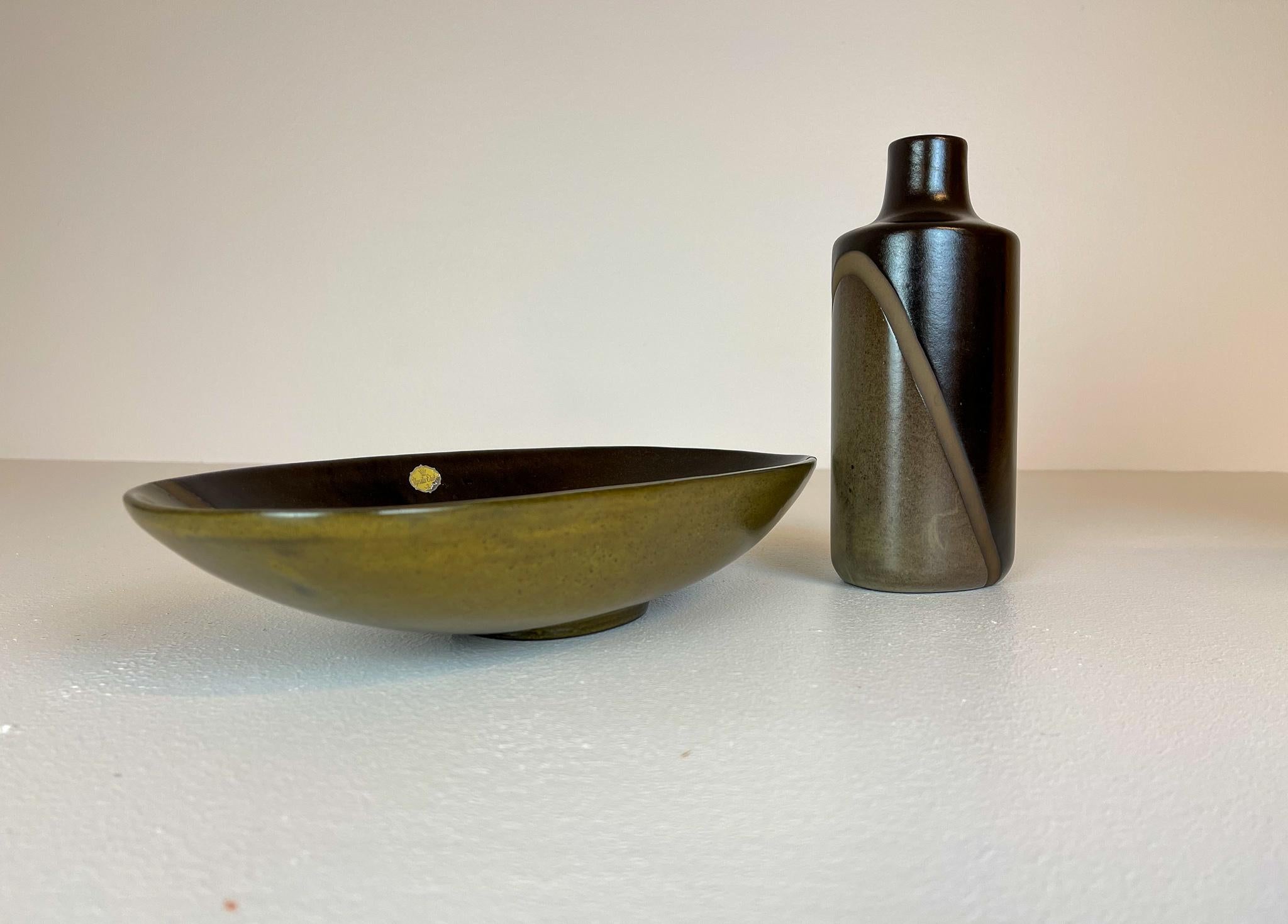 Cet ensemble de bol et de vas a été fabriqué en Suède en 1955 à Ekeby et conçu par le célèbre Hjördis Oldfors. 
Elle est faite de 2 couleurs différentes et d'une ligne qui coupe comme une diagonale pour les plonger. C'est une pièce de céramique