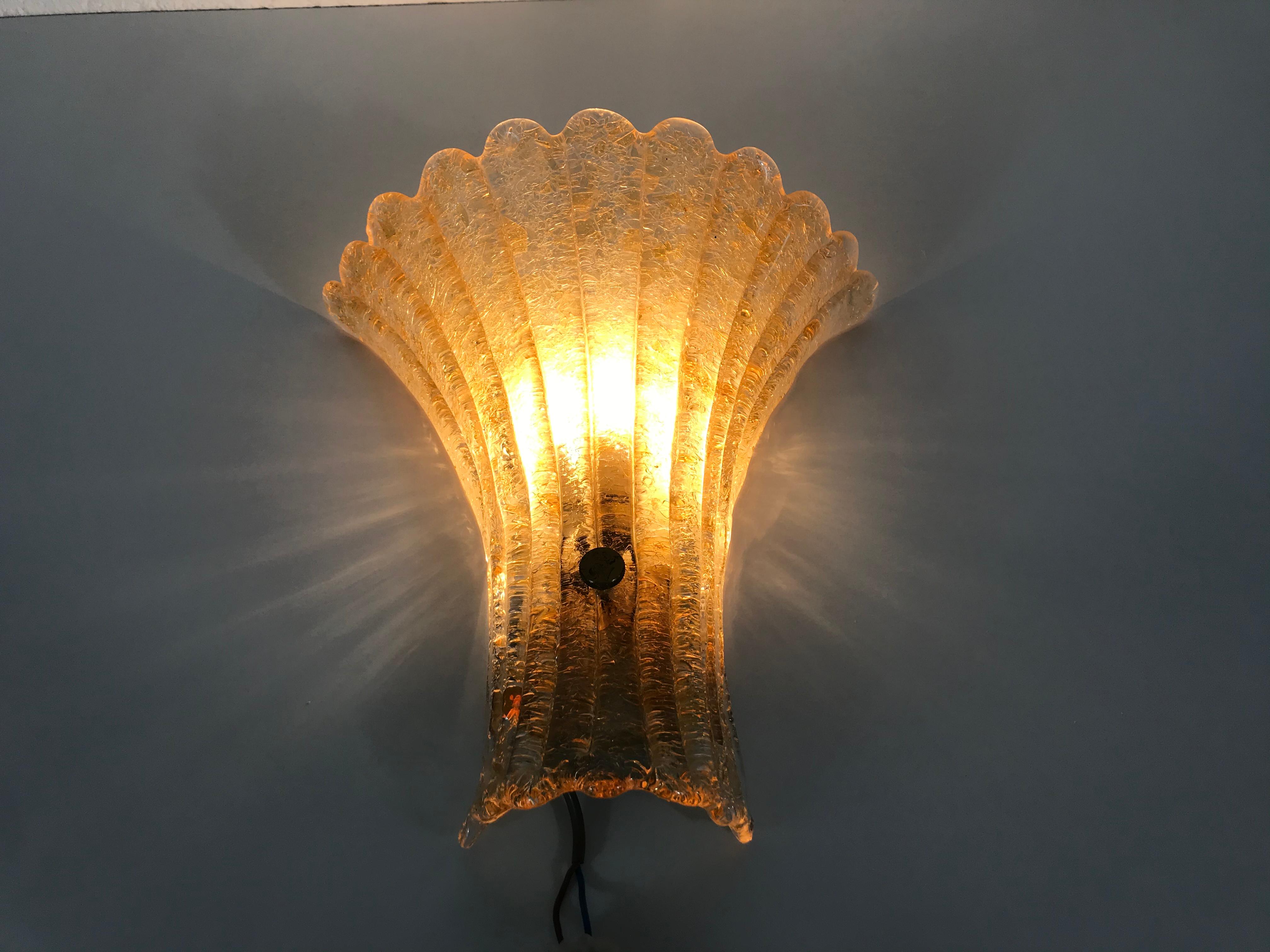 Midcentury beautiful wall light by the German brand Doria made in the 1960s. It has a beautiful shell shape. The unique glass shade is made from murano glass.