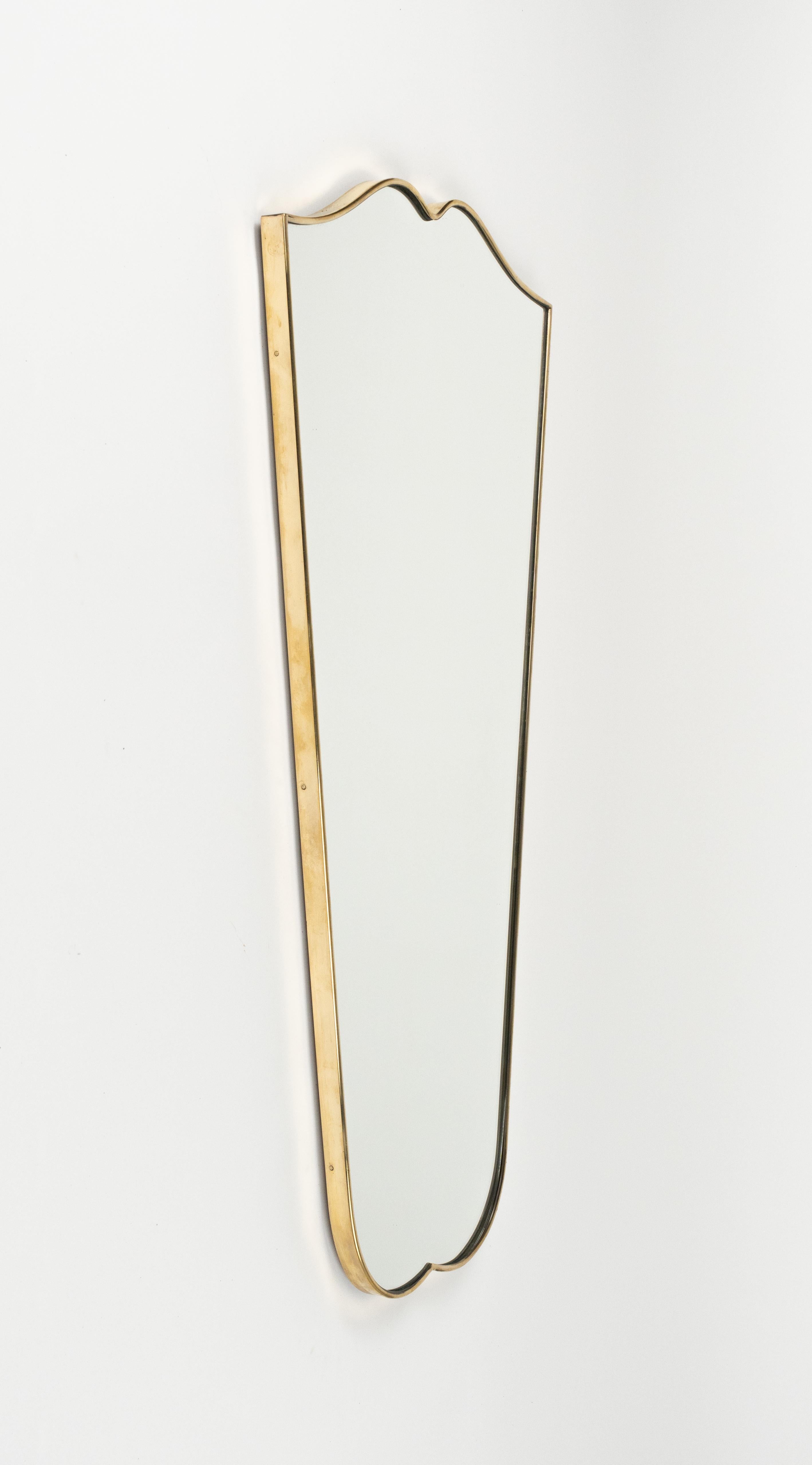 Specchio da parete a forma di scudo in ottone nello stile di Gio Ponti.  

Prodotto in Italia negli anni '50.  

Vanta un design elegante e raffinato con linee pulite e un'estetica minimalista.  

Si tratta di un'opera d'arte bella e funzionale che