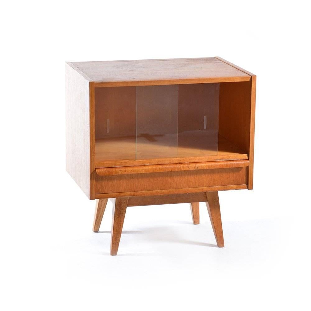 Vintage showcase or a small sideboard produced in Czechoslovakia by Tatra furniture company in the 1960s. Interesting, timeless design and a beautiful simple shapes. Sliding glass doors on the showcase and a drawer underneath. Some wear visible on