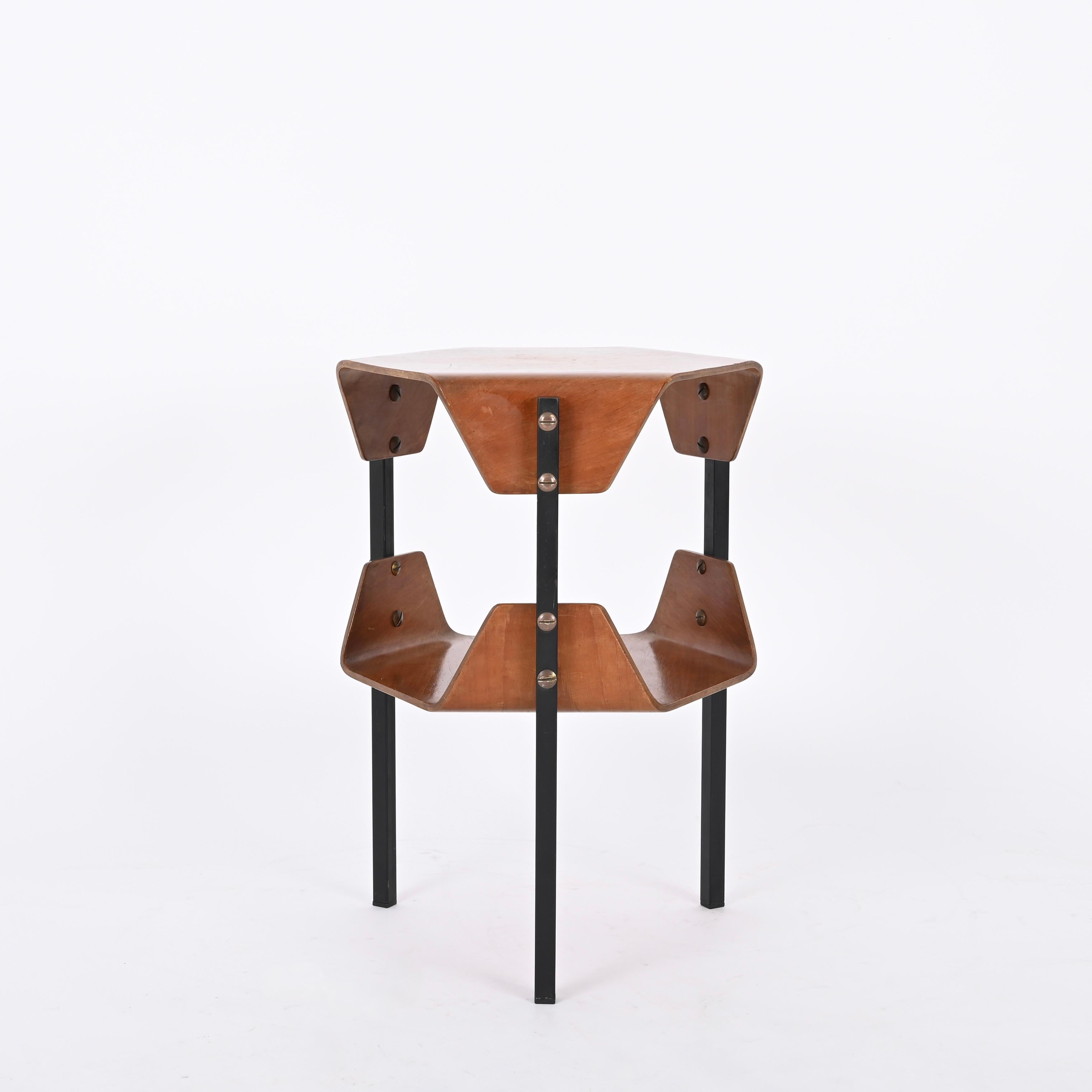Magnificent side table designed by Campo e Graffi and produced in Italy during the late 1950s. 

This charming two-tier side table is unique thanks to the stunning tops in bent walnut that are connected to three legs in black enameled metal by a
