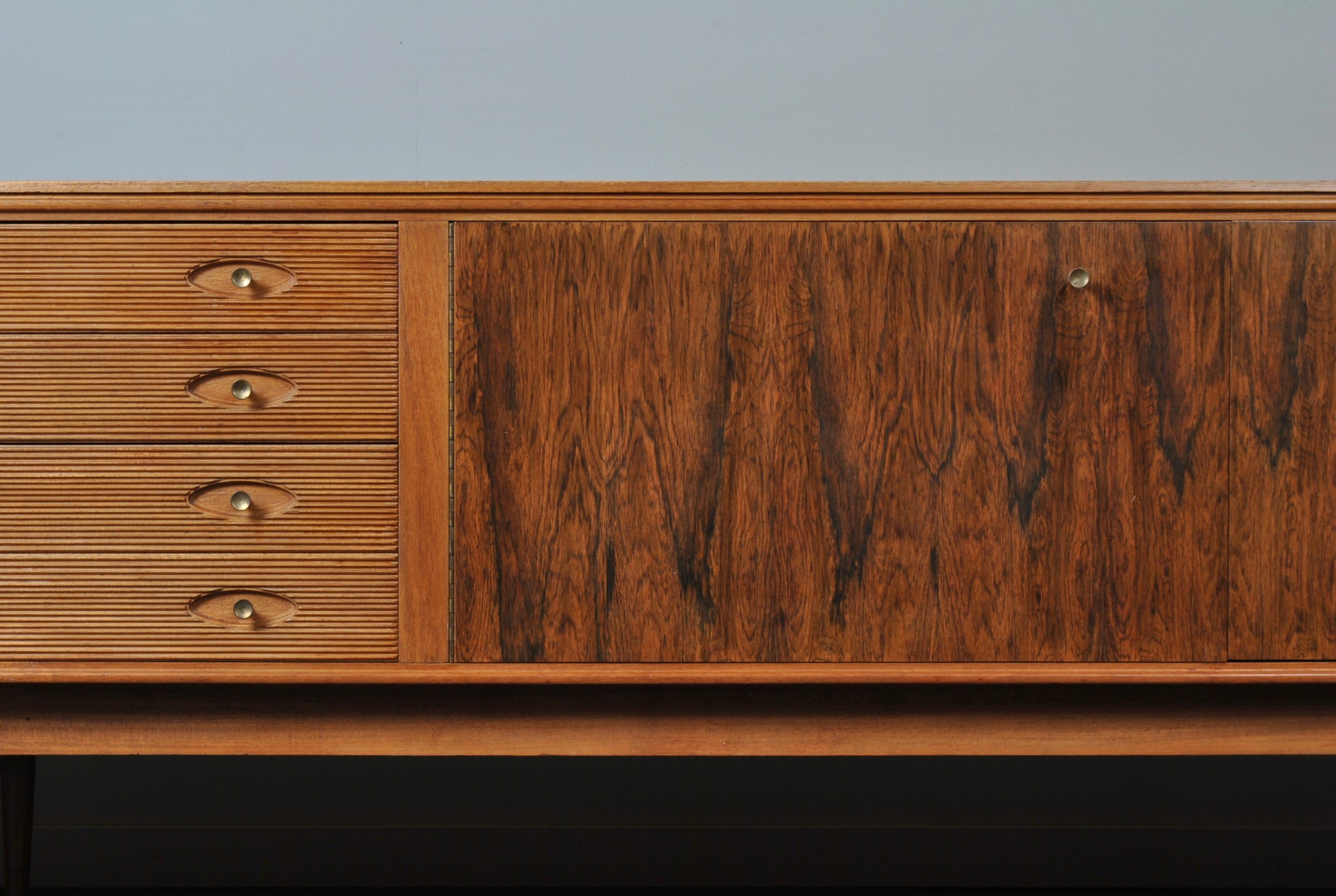 A large midcentury sideboard by Archie Shine. A Classic design by Robert Heritage with trademark reeded drawer fronts and brass handles. Produced in the UK circa 1960. A very stylish yet totally practical piece of midcentury design furniture.