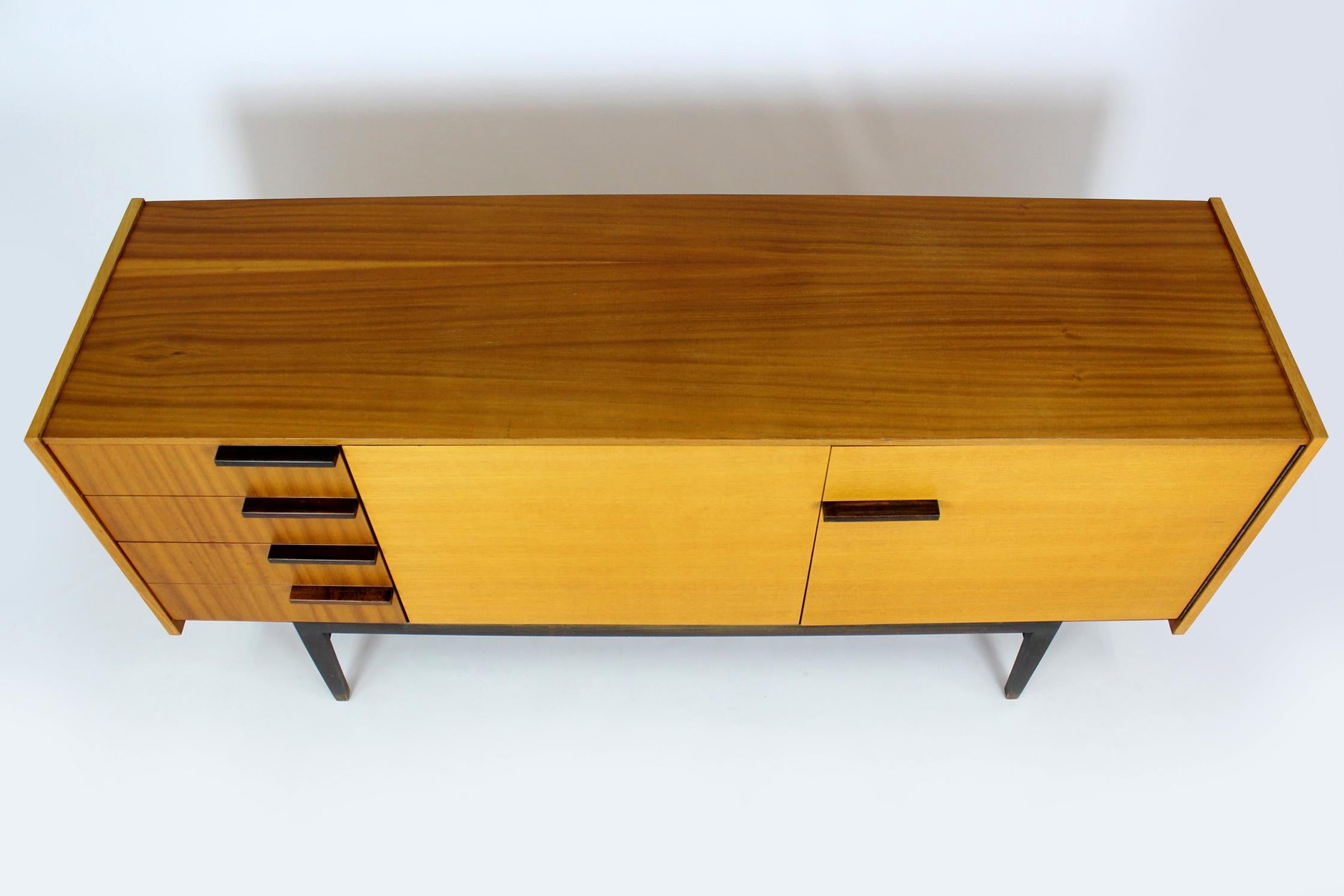 
This  ash & mahogany sideboard was manufactured in 1970 by UP Zavody in Czechoslovakia. It has 4 drawers and 3 shelves inside. The sideboard is preserved in its original, very good condition.
We have more furniture from this set (wardrobe,
