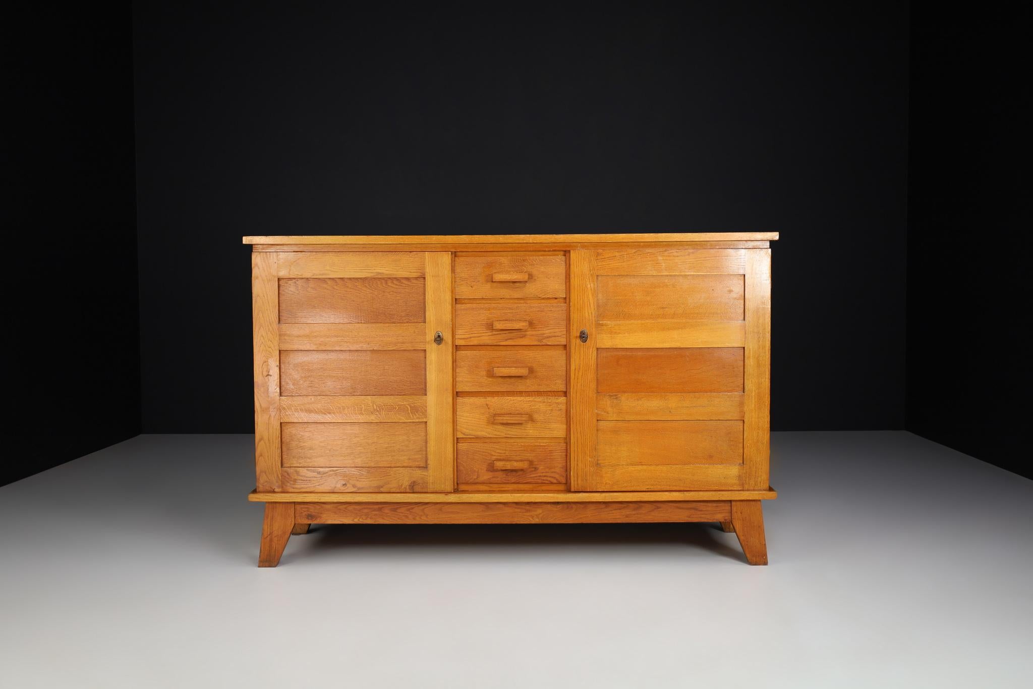 Midcentury sideboard in patinated Blonde French oak by René Gabriel, France, 1940s

Published in 1944 and designed by René Gabriel, this sideboard dates back to the 1940s and is a typical example of so-called reconstruction furniture. The design