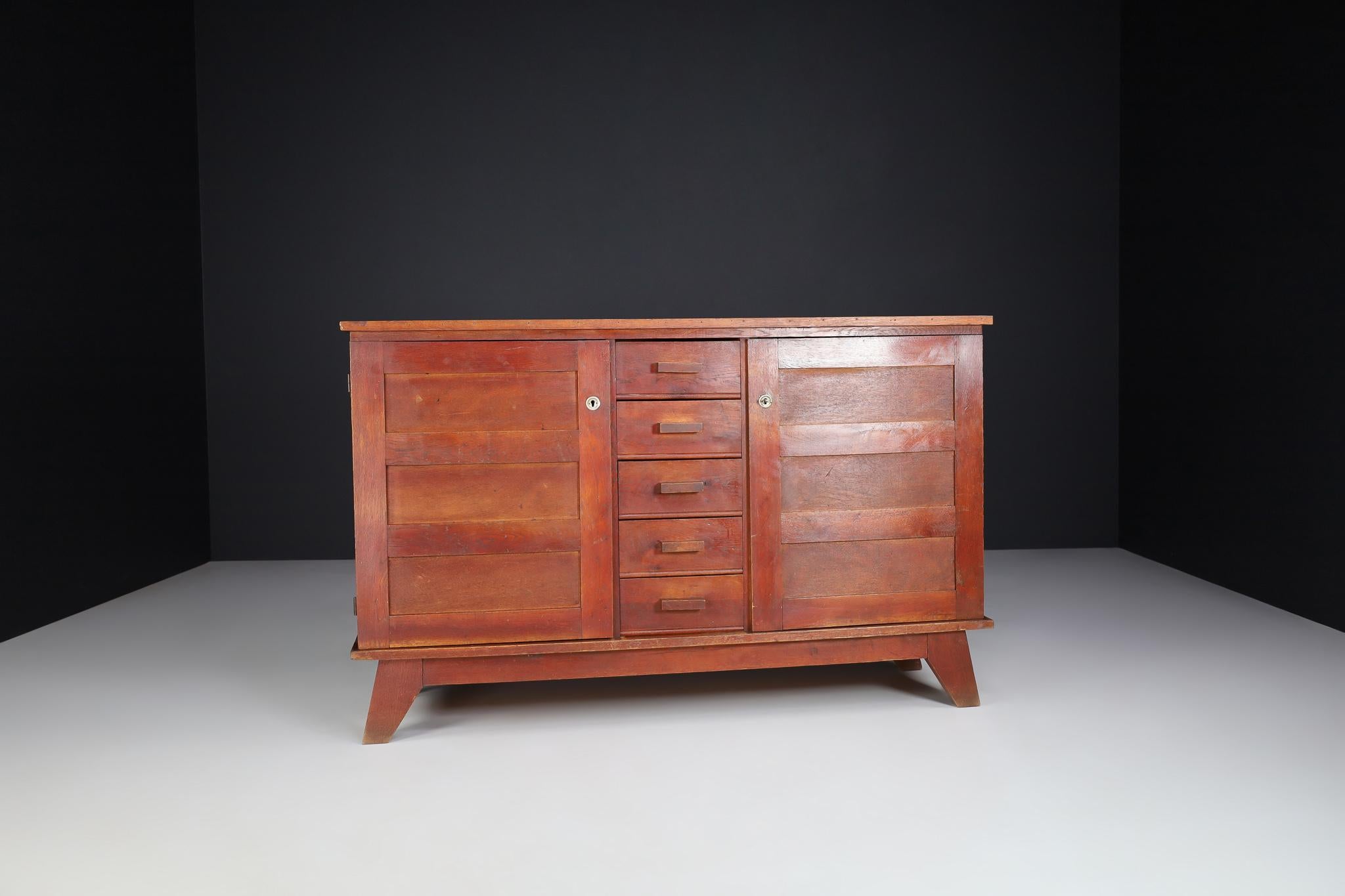 Midcentury sideboard in patinated French oak by René Gabriel, France, 1940s

Published in 1944 and designed by René Gabriel, this sideboard dates back to the 1940s and is a typical example of so-called reconstruction furniture. The design of