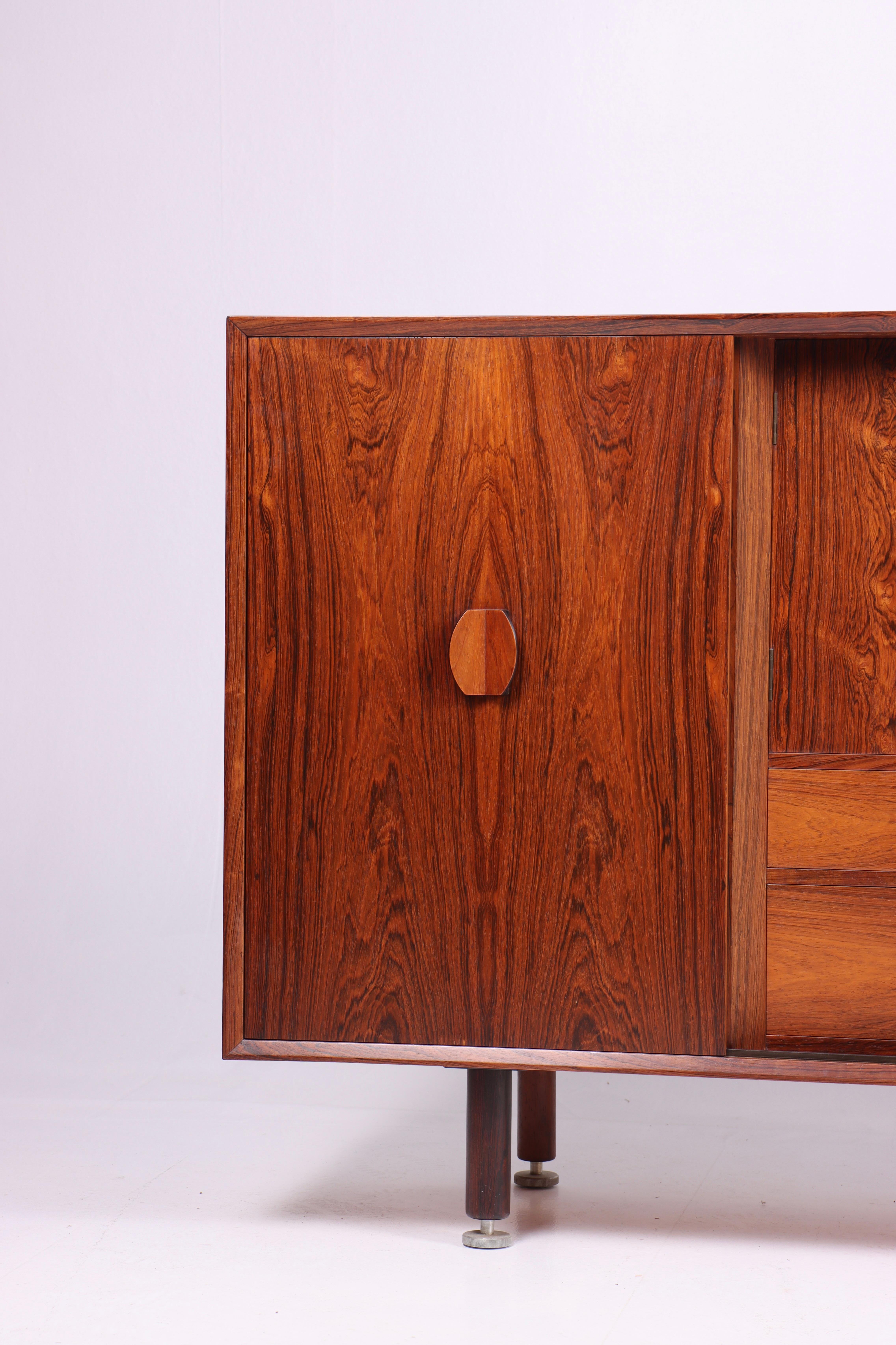 Buffet danois des années 1960, conçu par le célèbre designer de meubles Jens Risom.

Le buffet se caractérise par son magnifique bois de rose, qui apporte chaleur et caractère à tout espace. Les veinures naturelles et les couleurs variées du bois