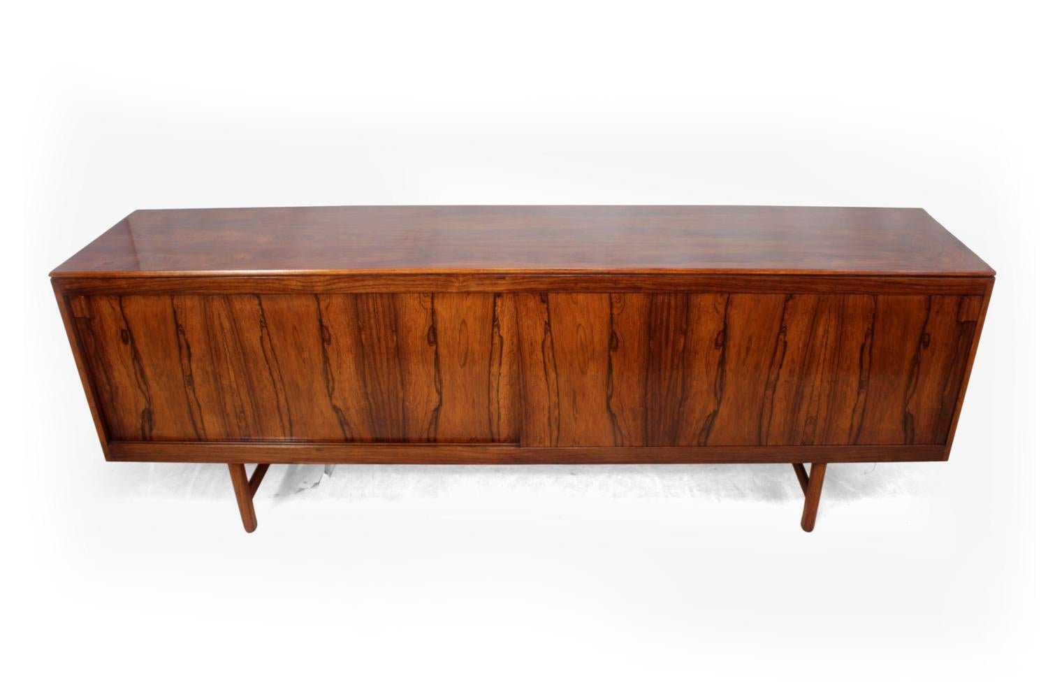 Midcentury sideboard in rosewood

A 1960s Danish rosewood sideboard with two long sliding doors, to the left has drawers behind and to the right is a shelf. The sideboard has been fully restored and hand polished and is in very good condition