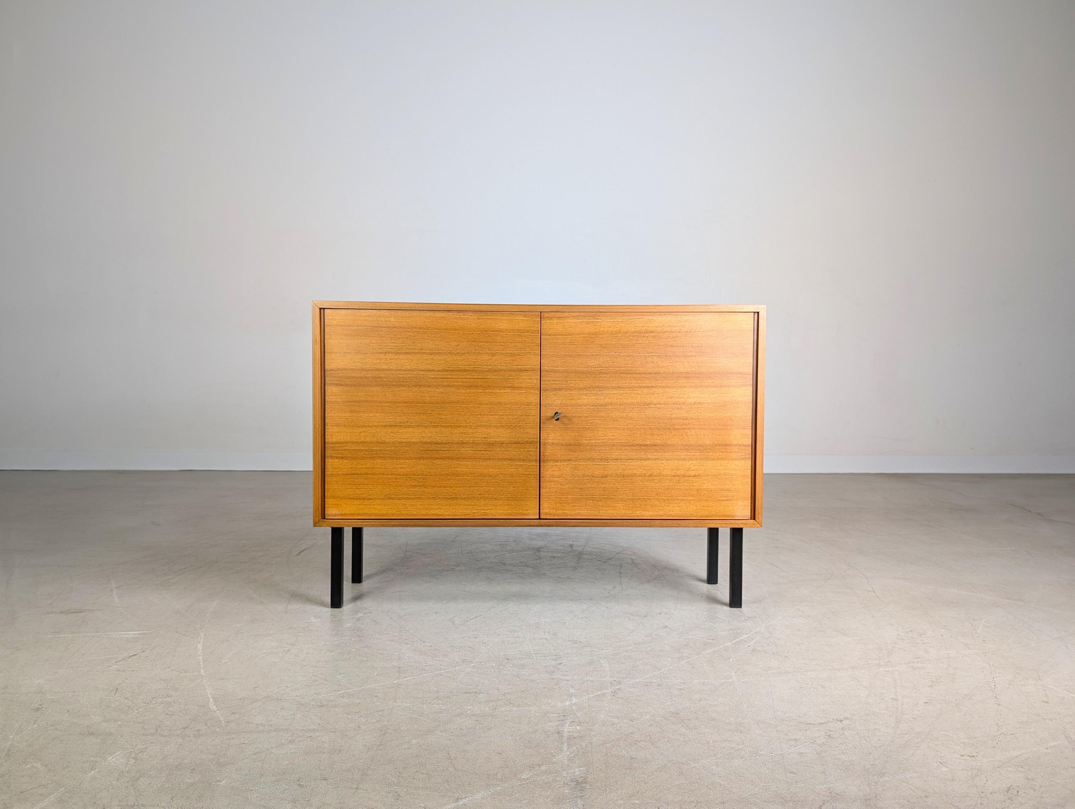 Wir bieten eine hochwertige kleine Kommode aus Nussbaumholz aus den 1960er Jahren zum Verkauf an. Das Möbel verfügt über zwei abschließbare Türen und lässt sich aufgrund seiner minimalistischen Formgebung sehr gut auch in moderne Wohnräume