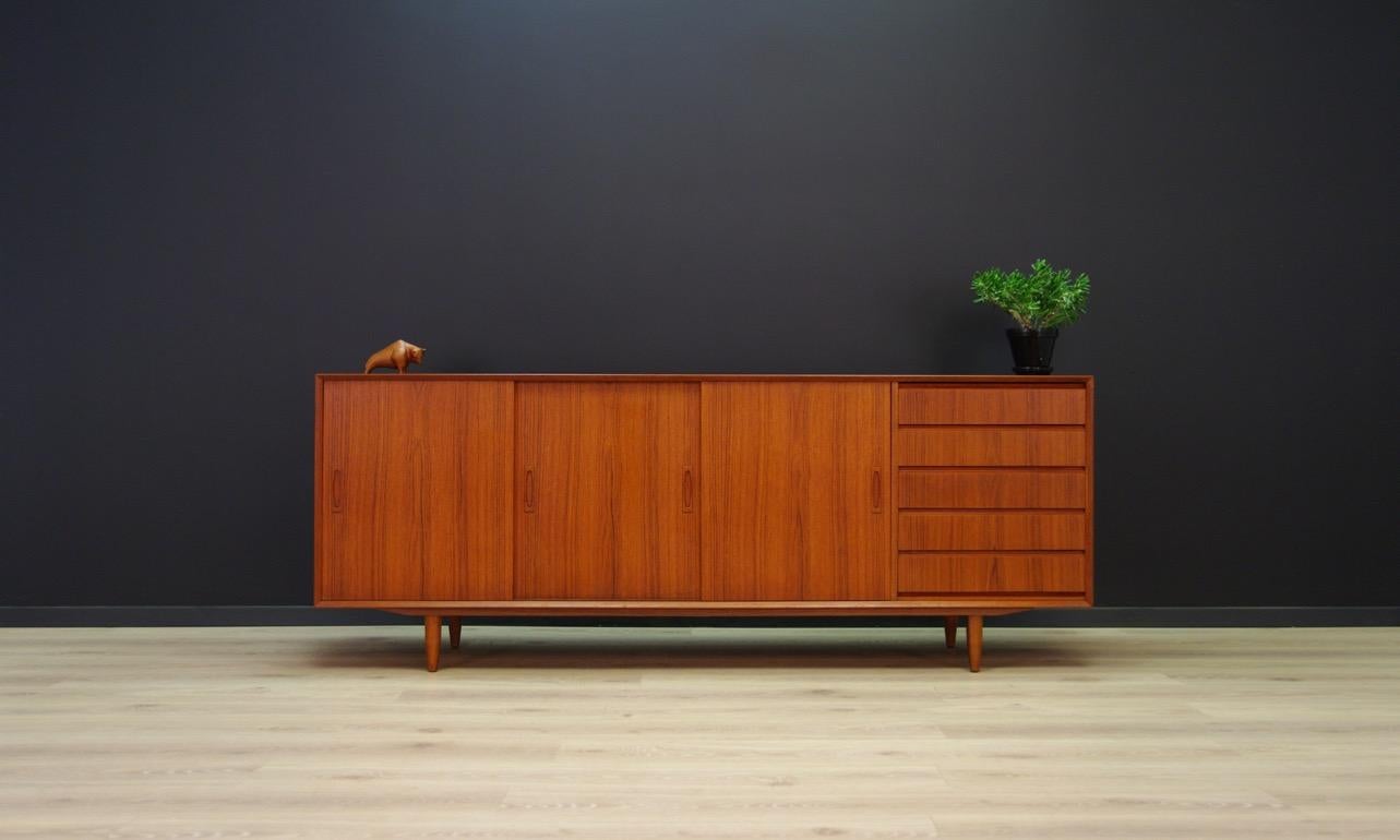 Phenomenal sideboard, Danish minimalism from the 1960s-1970s, a Classic form. Inside, there are practical shelves behind sliding doors and five external utility drawers. Sideboard veneered with teak. Preserved in good condition (small bruises and