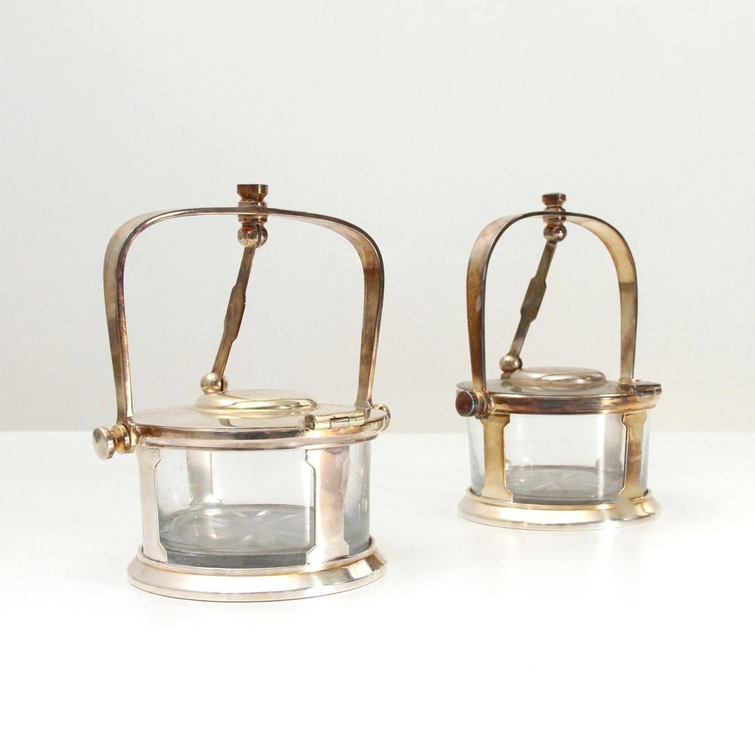 Pair of Parmesan cheese cellar produced by Fratelli Calderoni in the 1930s.
Silver alpaca structure.
Glass container with floral decoration.
Automatic lid opening by folding the handle.
Good general conditions, some signs due to normal use over