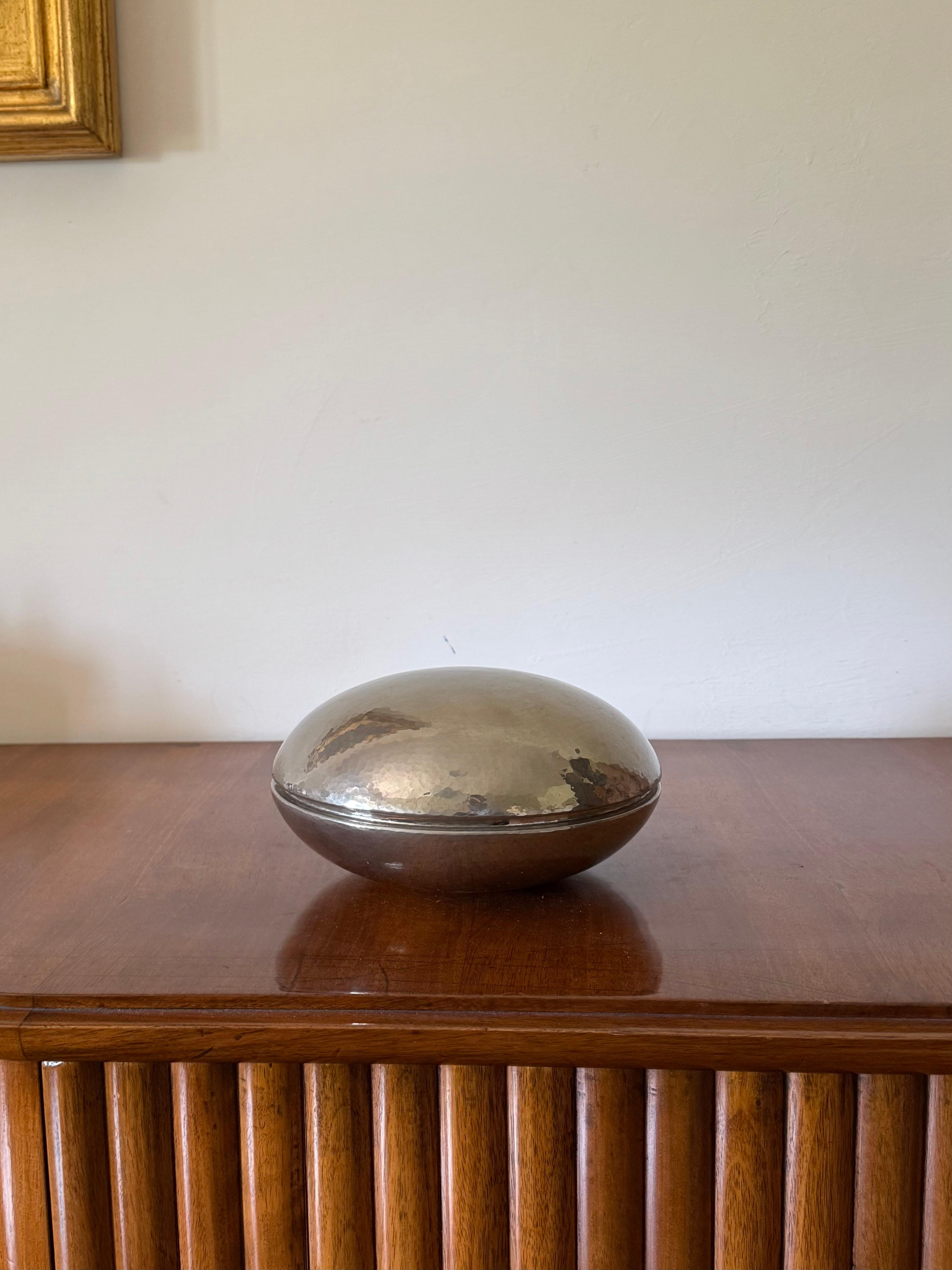 Midcentury silver-plated hand-hammered brass box 

Zanetto Padova Italy 1970s

Zanetto is a luxury craft company founded in 1963 in Padua. The company creates, entirely by hand, furnishing objects and tableware in bronze, copper, brass, silver and